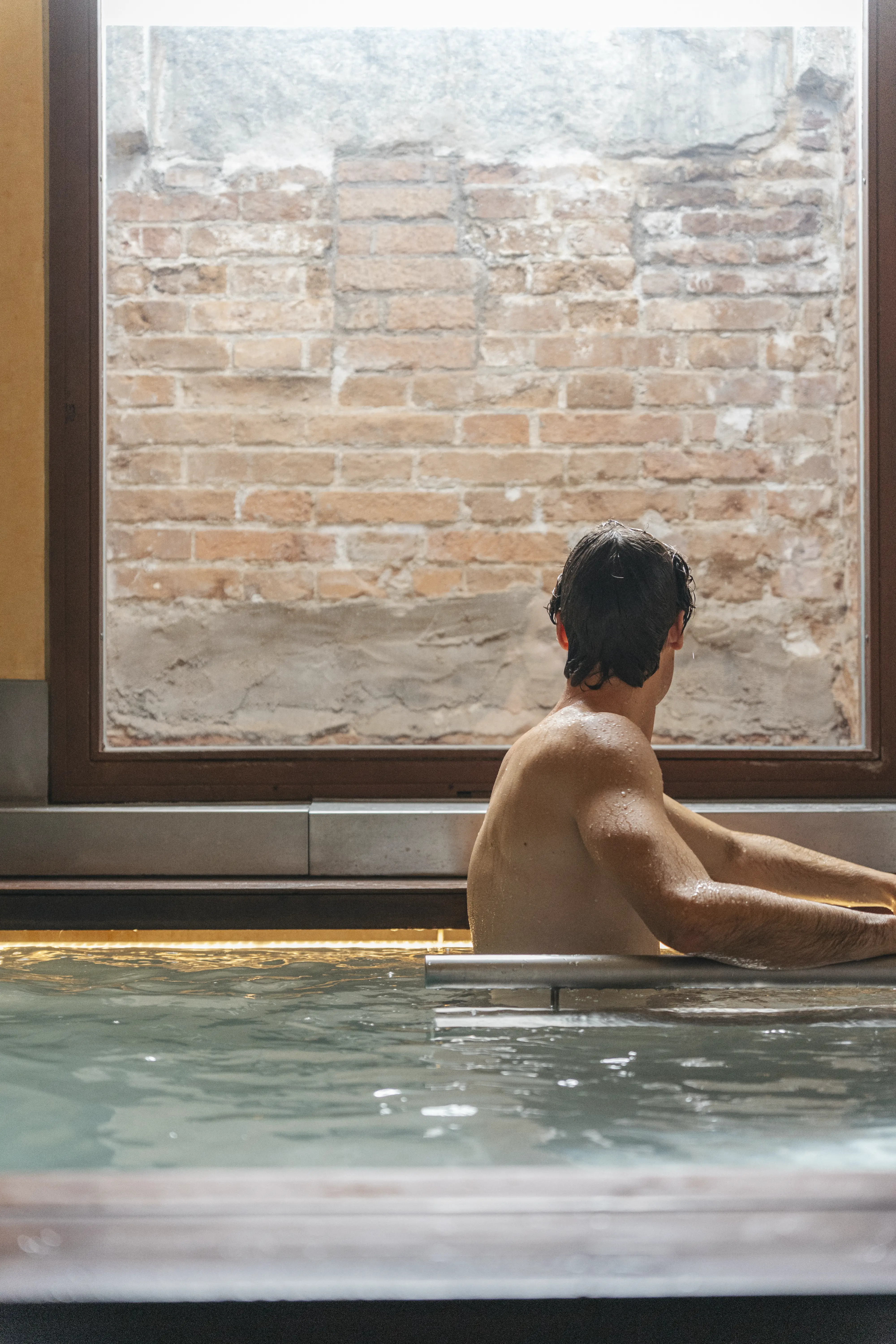 Hombre joven en aguas piscina spa