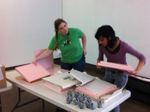 Two girls working with pink boxes