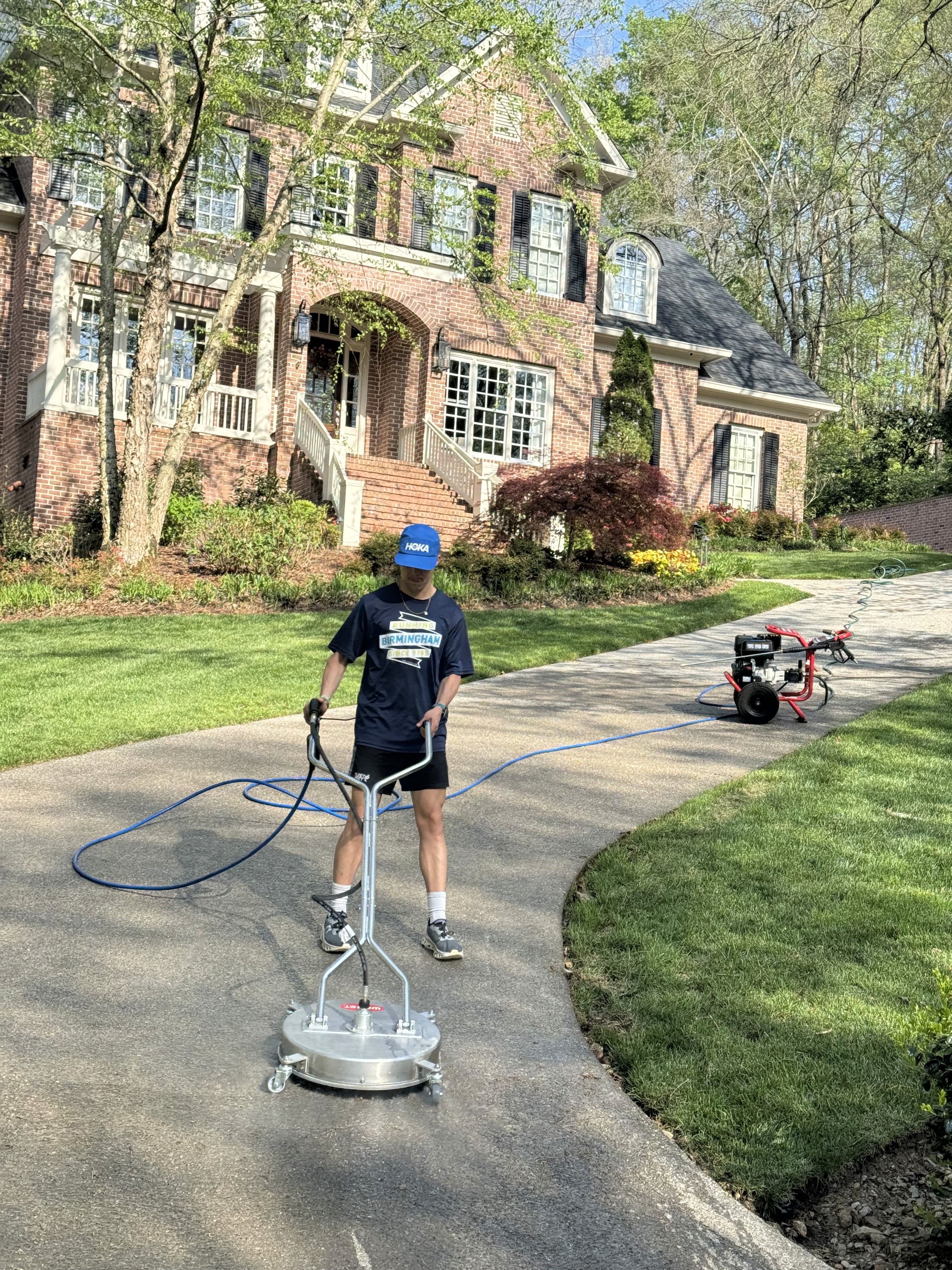 Settle Solutions' crew pressue washing a driveway