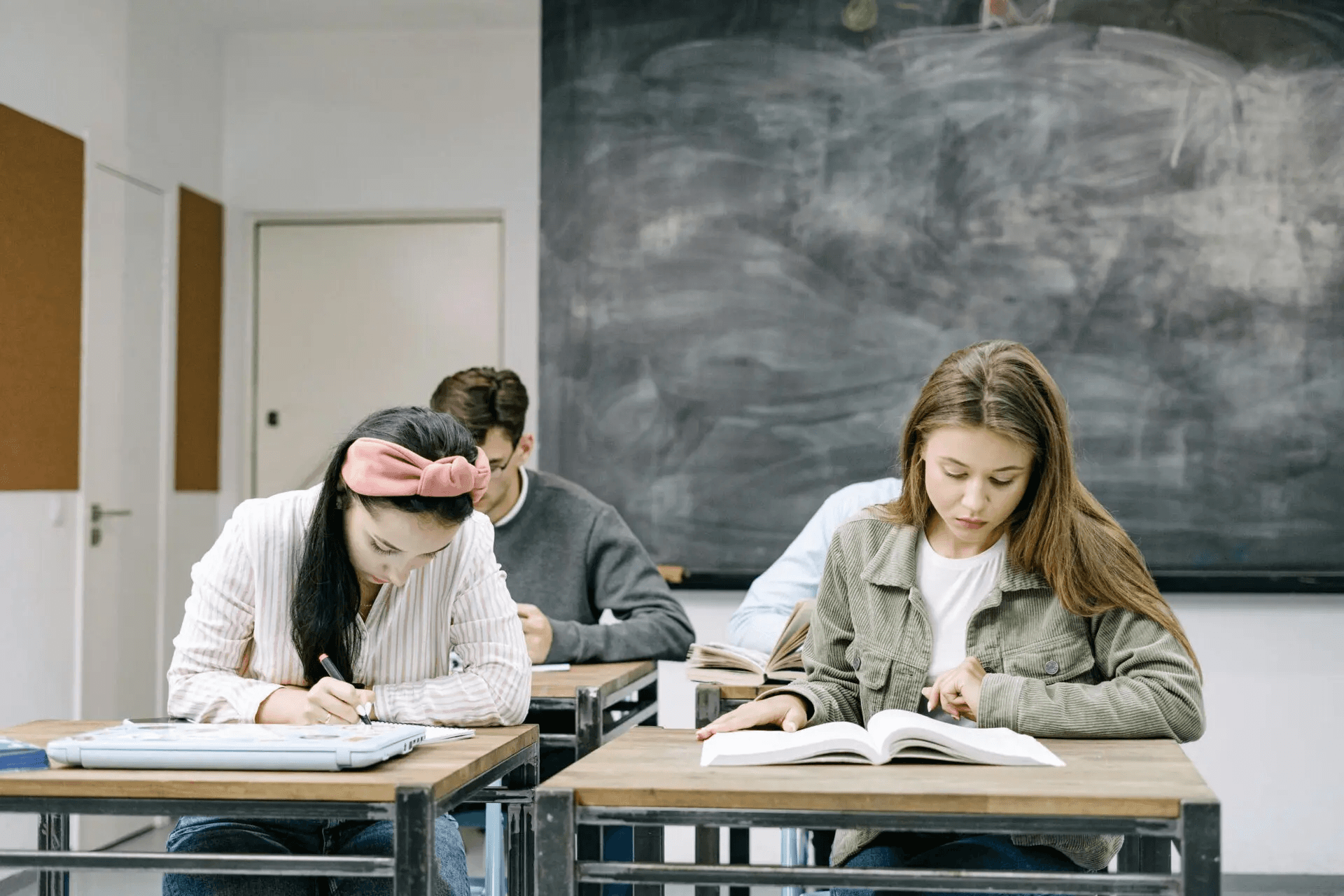 High school student reviewing academic journal submission guidelines at a desk with research papers