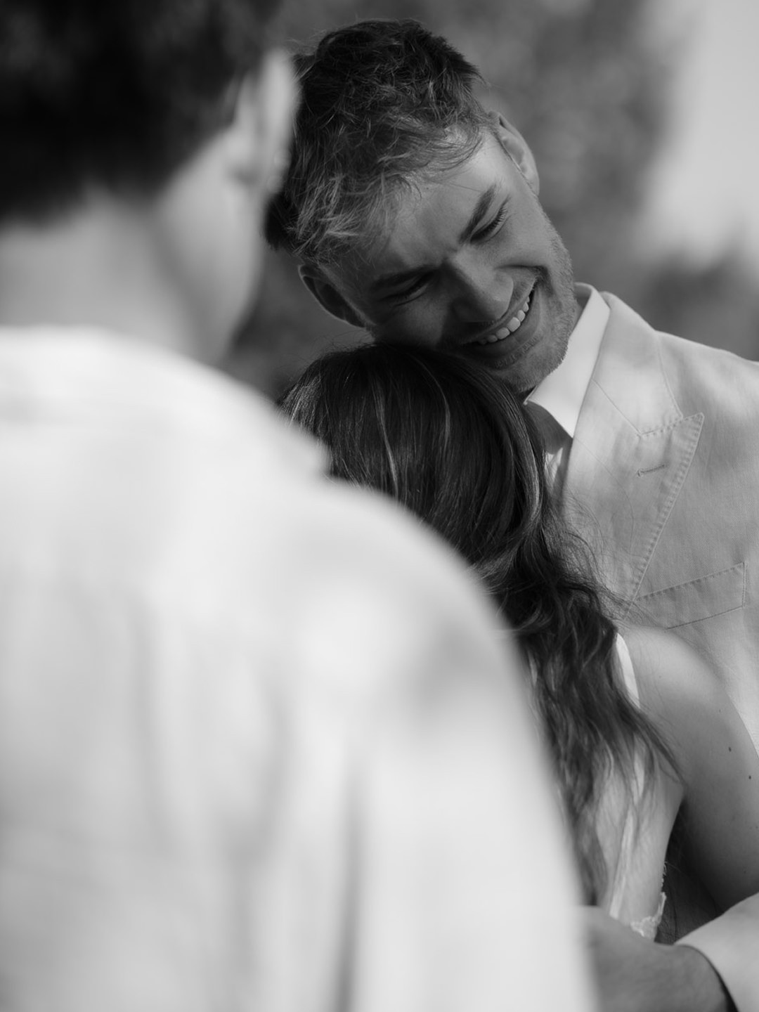 happy groom hugging his bride
