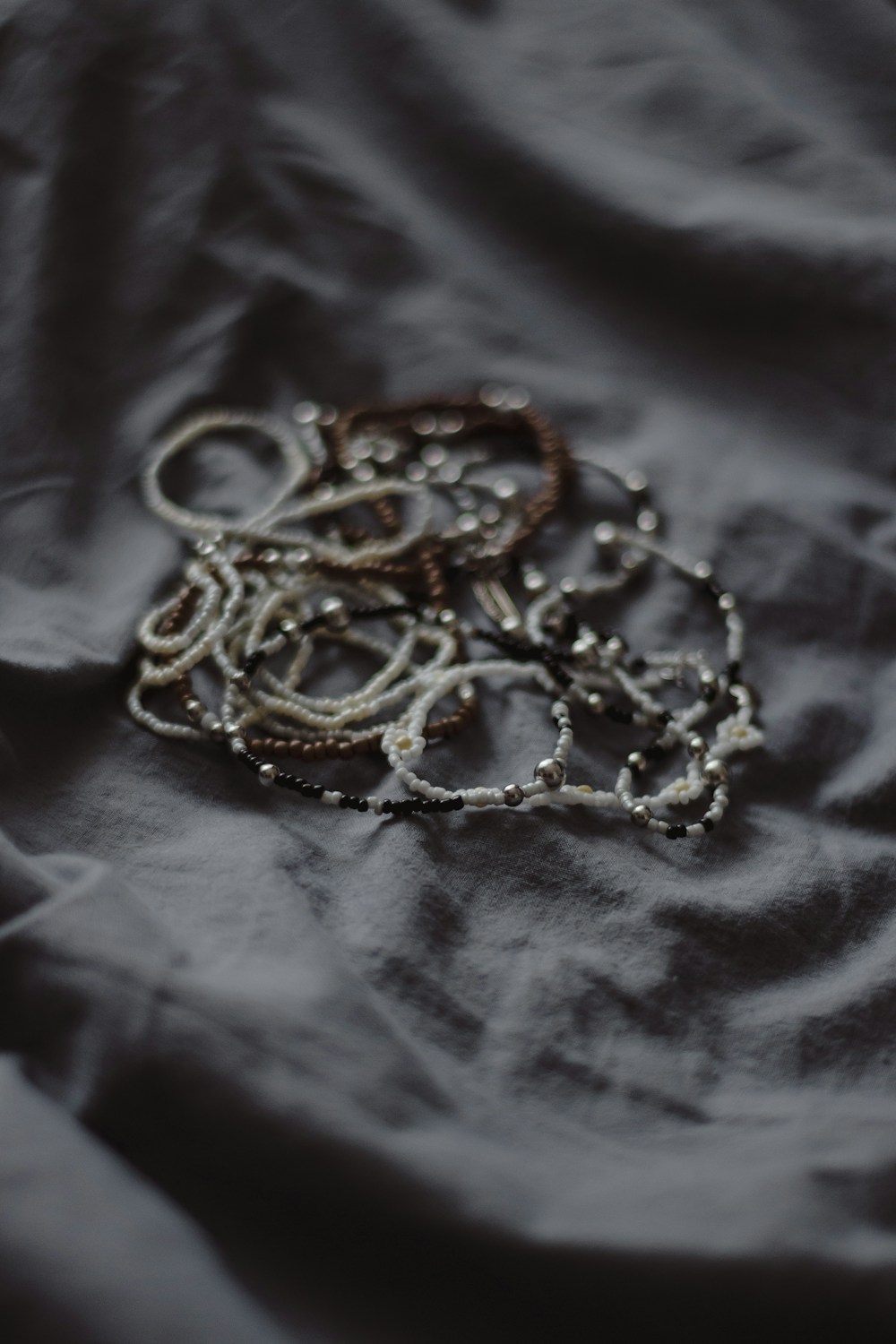 Baroque pearls and fine jewellery arranged on dark linen in soft natural light