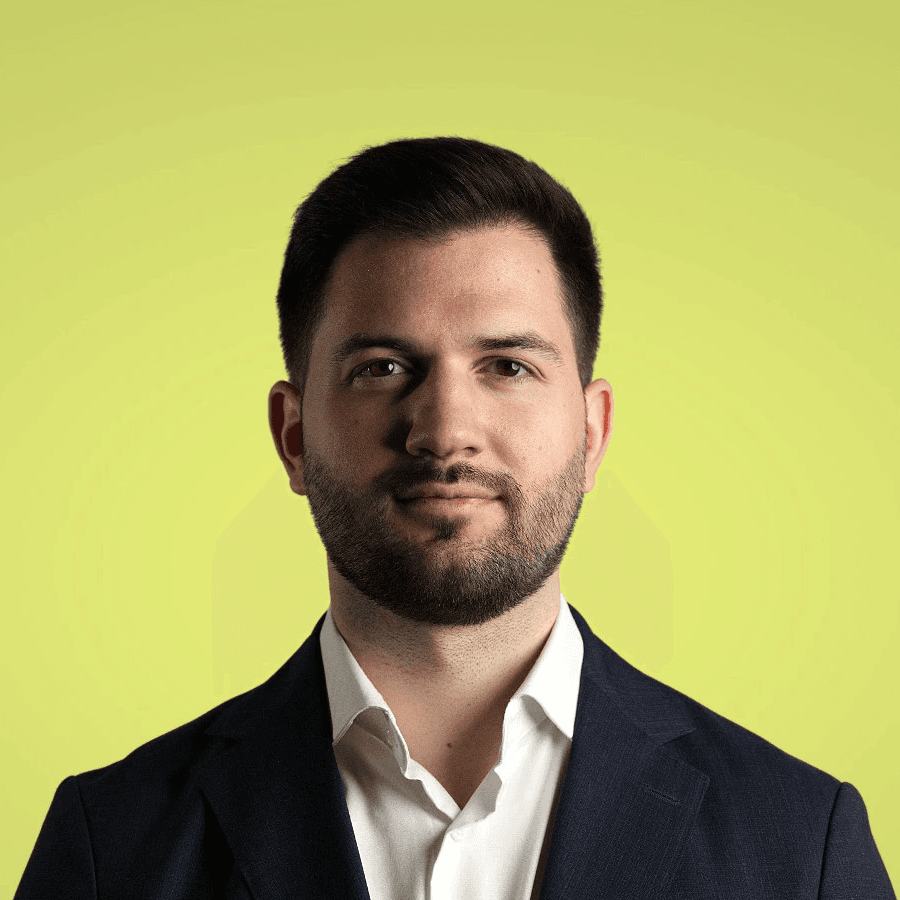 A young person with long, wavy hair sits in front of a plain background, looking directly at the camera.