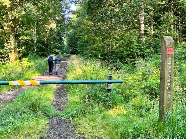 Two people starting the Callander Crags trail in Scotland. The red marker shows the total distance of the hike.