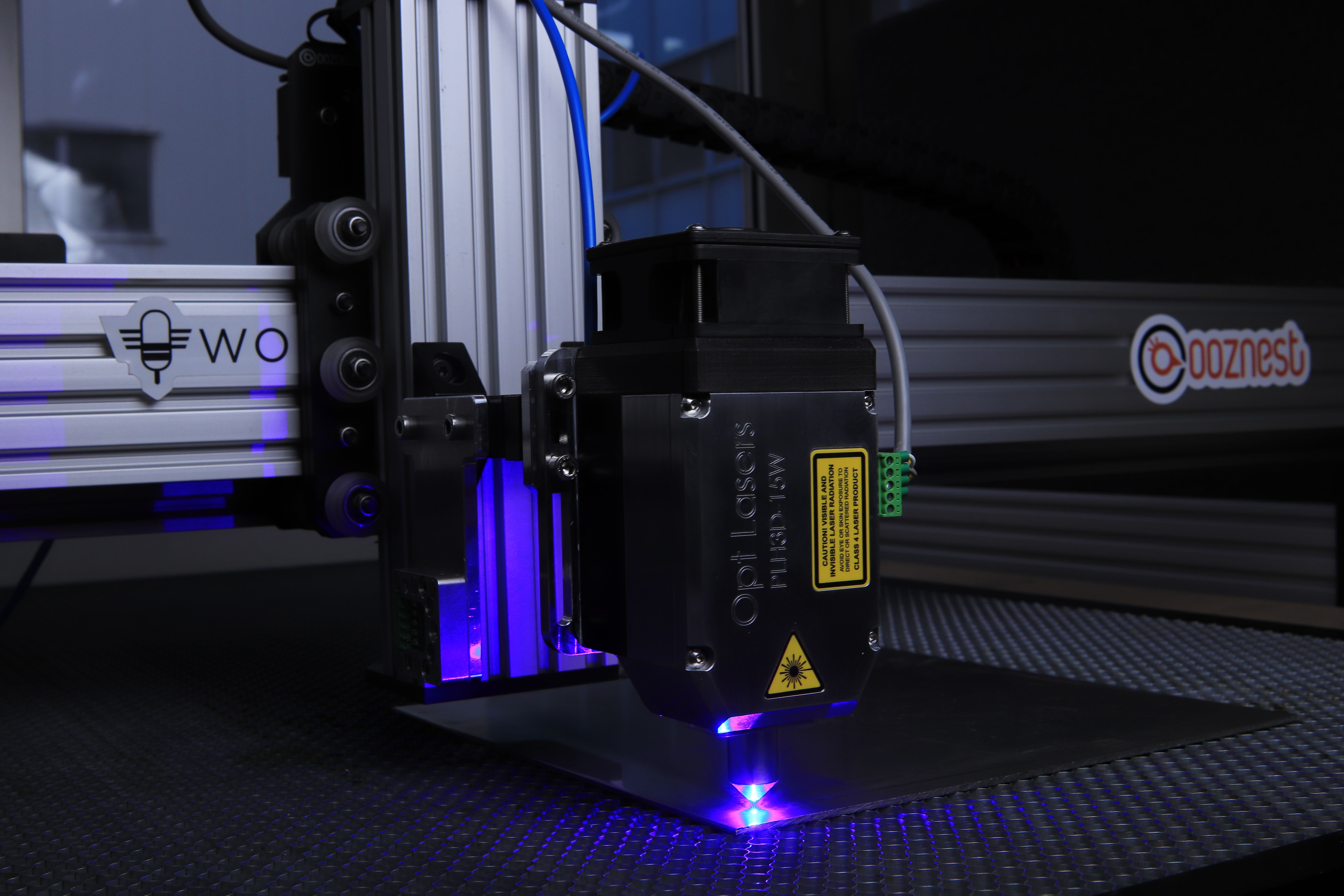 Close-up of an Opt Lasers PLH3D-15W laser cutting head engraving metal.