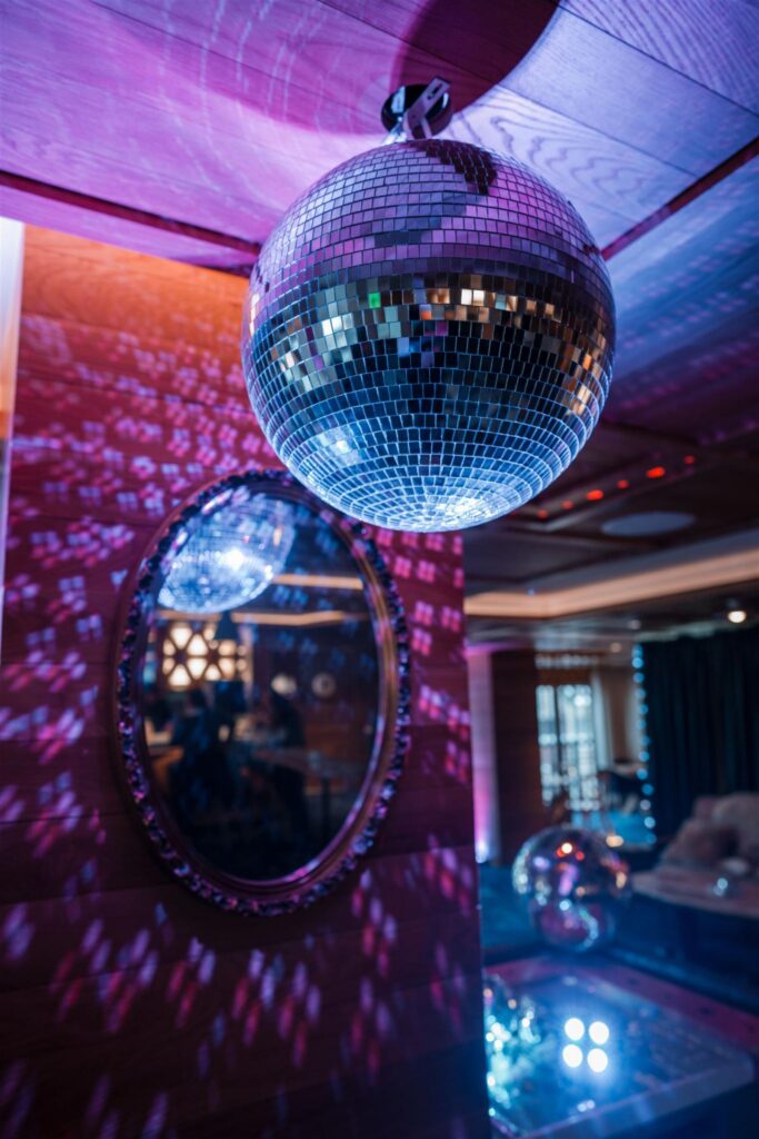Disco balls reflecting colored light across a wall