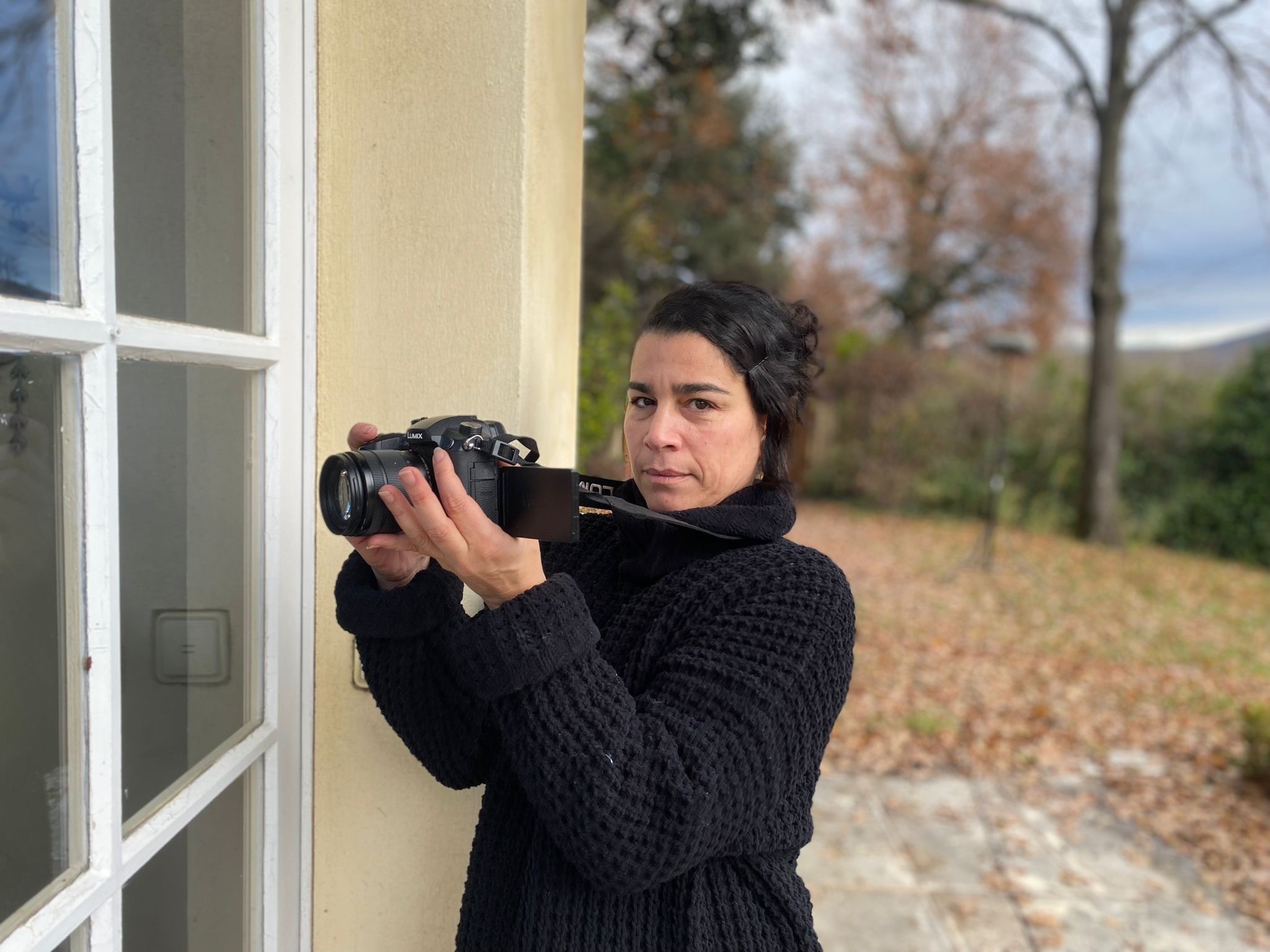 Woman in pink leather jacket crouching outdoors at night