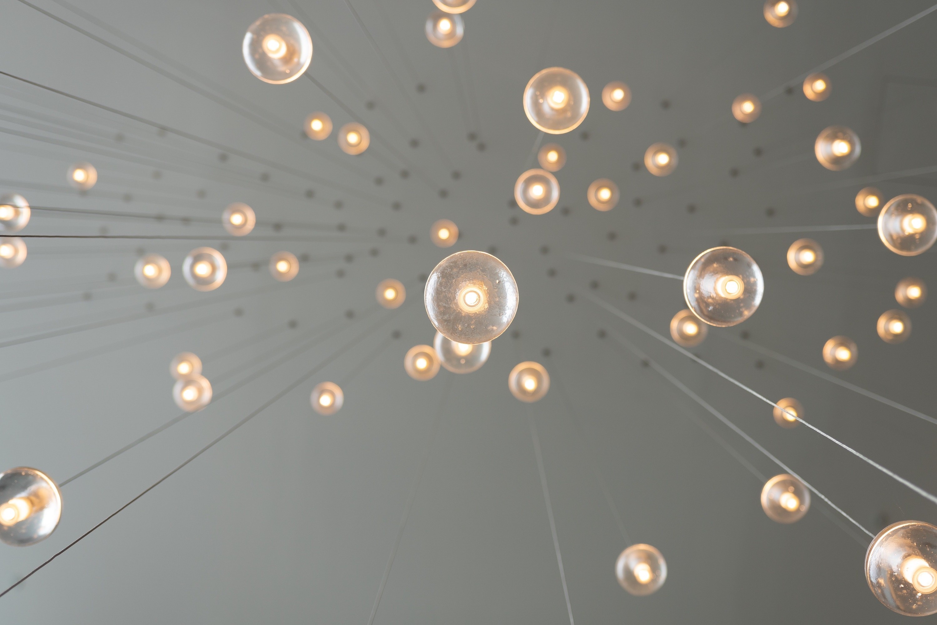 Glowing Edison bulbs suspended from above, viewed from below