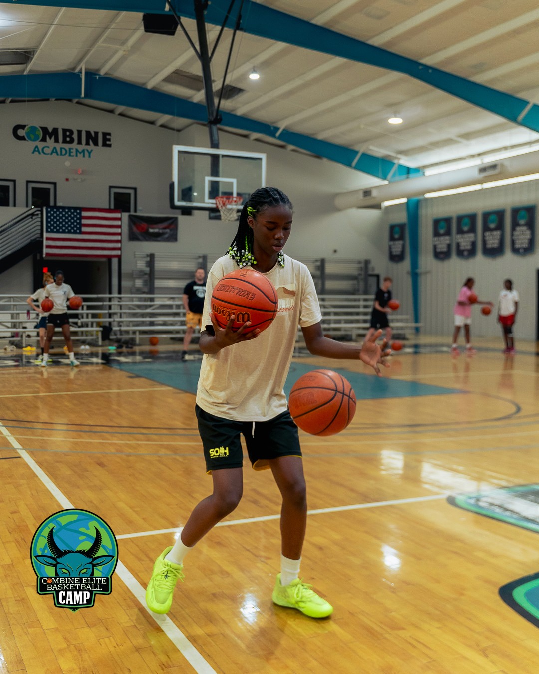 Jeune joueuse de basket pratiquant le dribble avec deux ballons en salle.