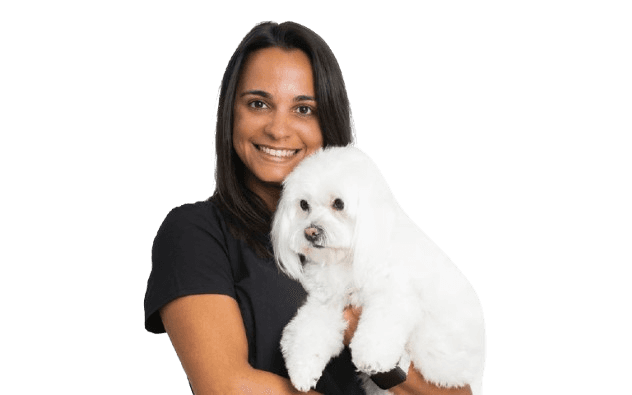 An image of Dr. Ines holding a white dog in her arms.
