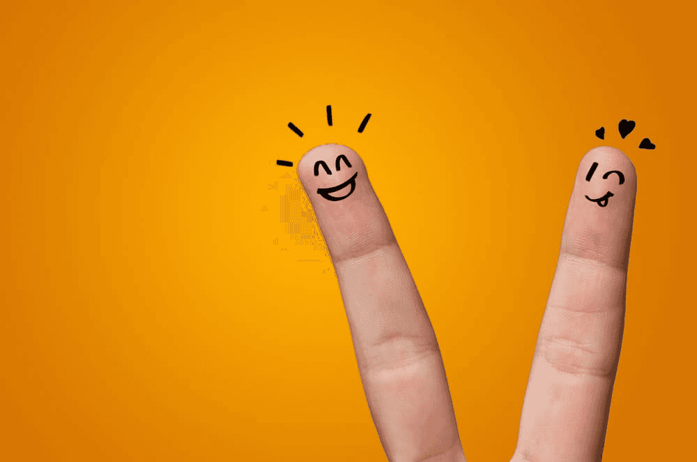 A hand with a heart on it against an orange background.