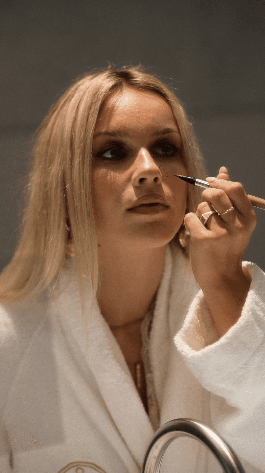 Bride sitting on ground against wall, groom standing nearby