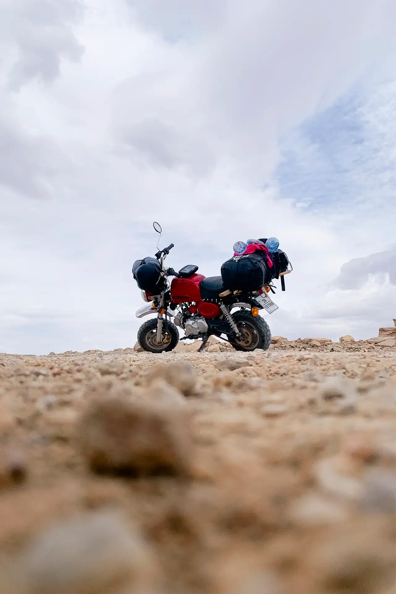 Low-angle image of a motorcycle parked on gravel