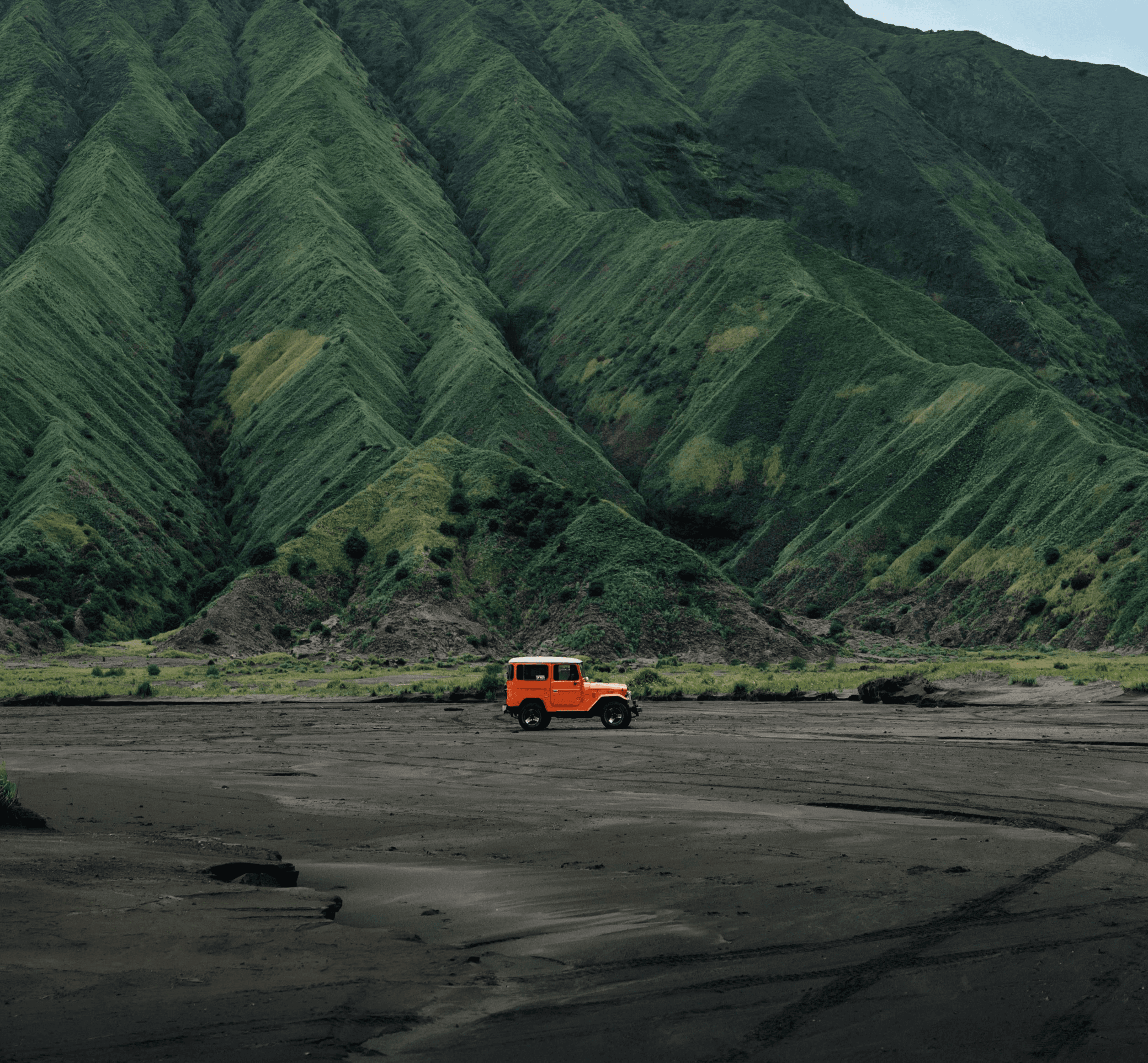 a truck is parked in front of a mountain