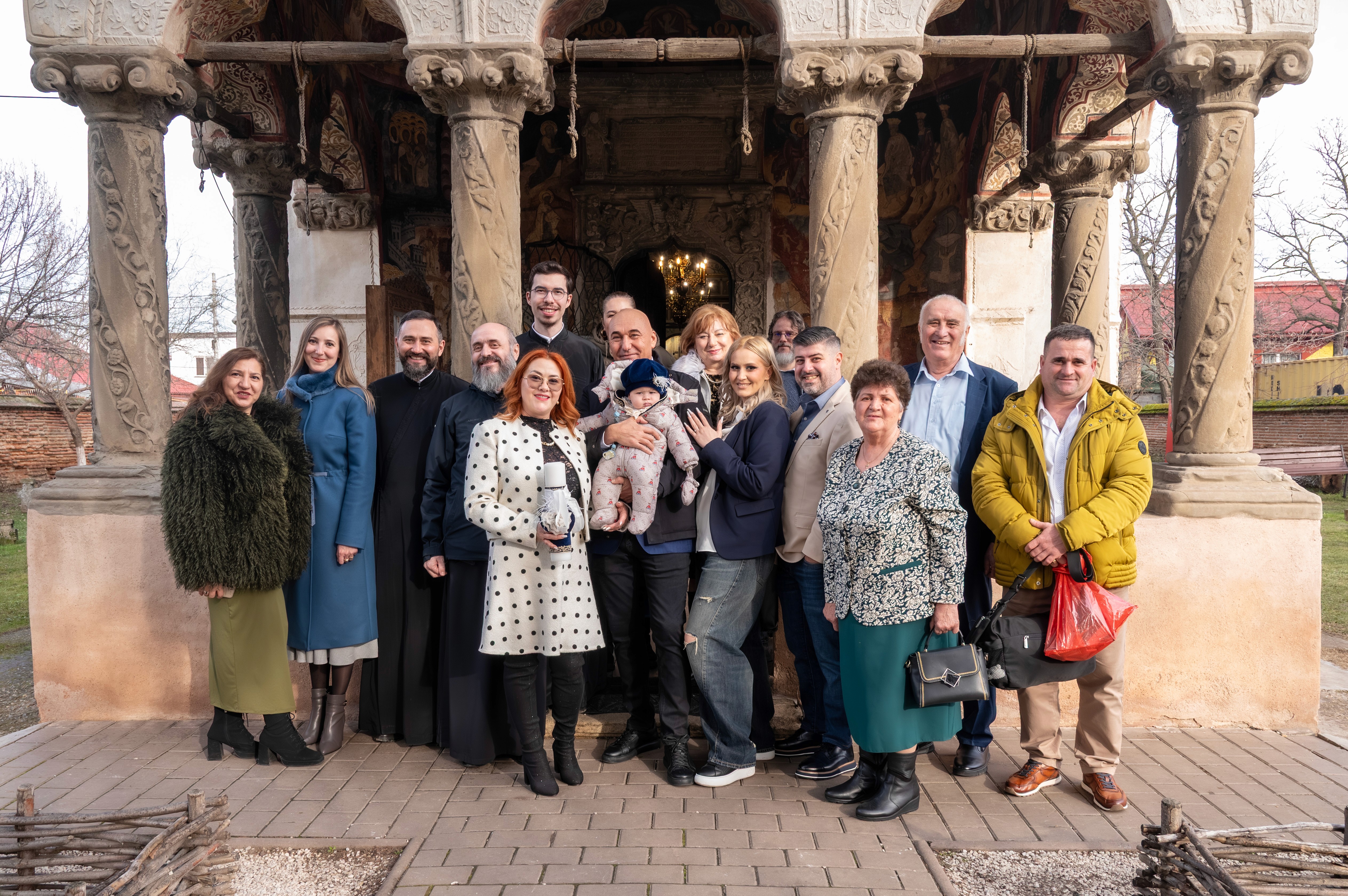 Familie extinsă fotografiată în fața bisericii Fundeni Doamnei dupa botezul copilului.
