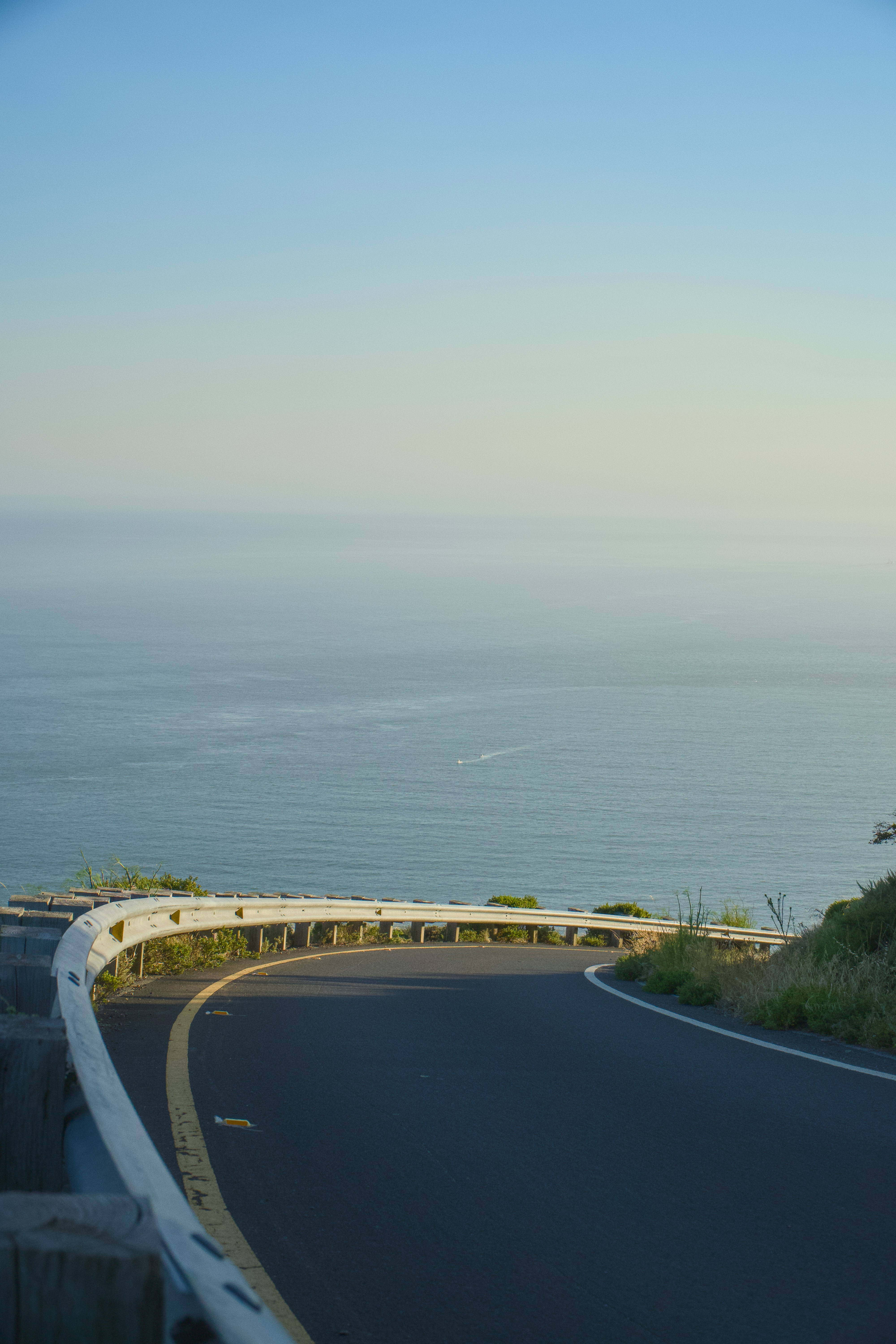 A curved road near the ocean on a sunny day