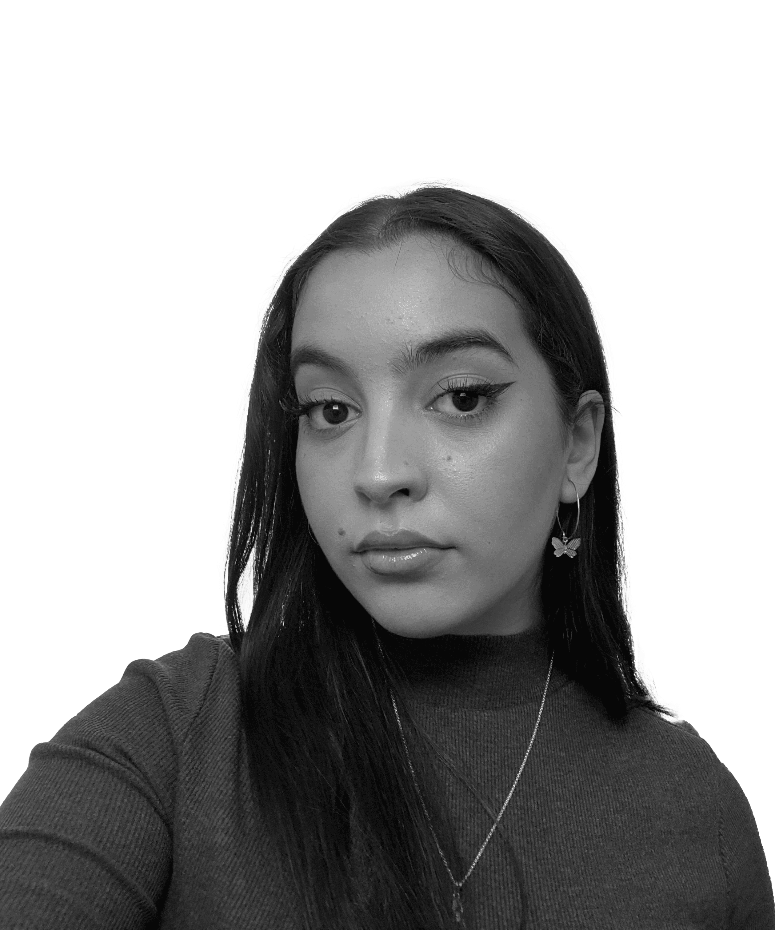 A young person with long dark hair, wearing a sweater, looking thoughtfully at the camera with a neutral expression.