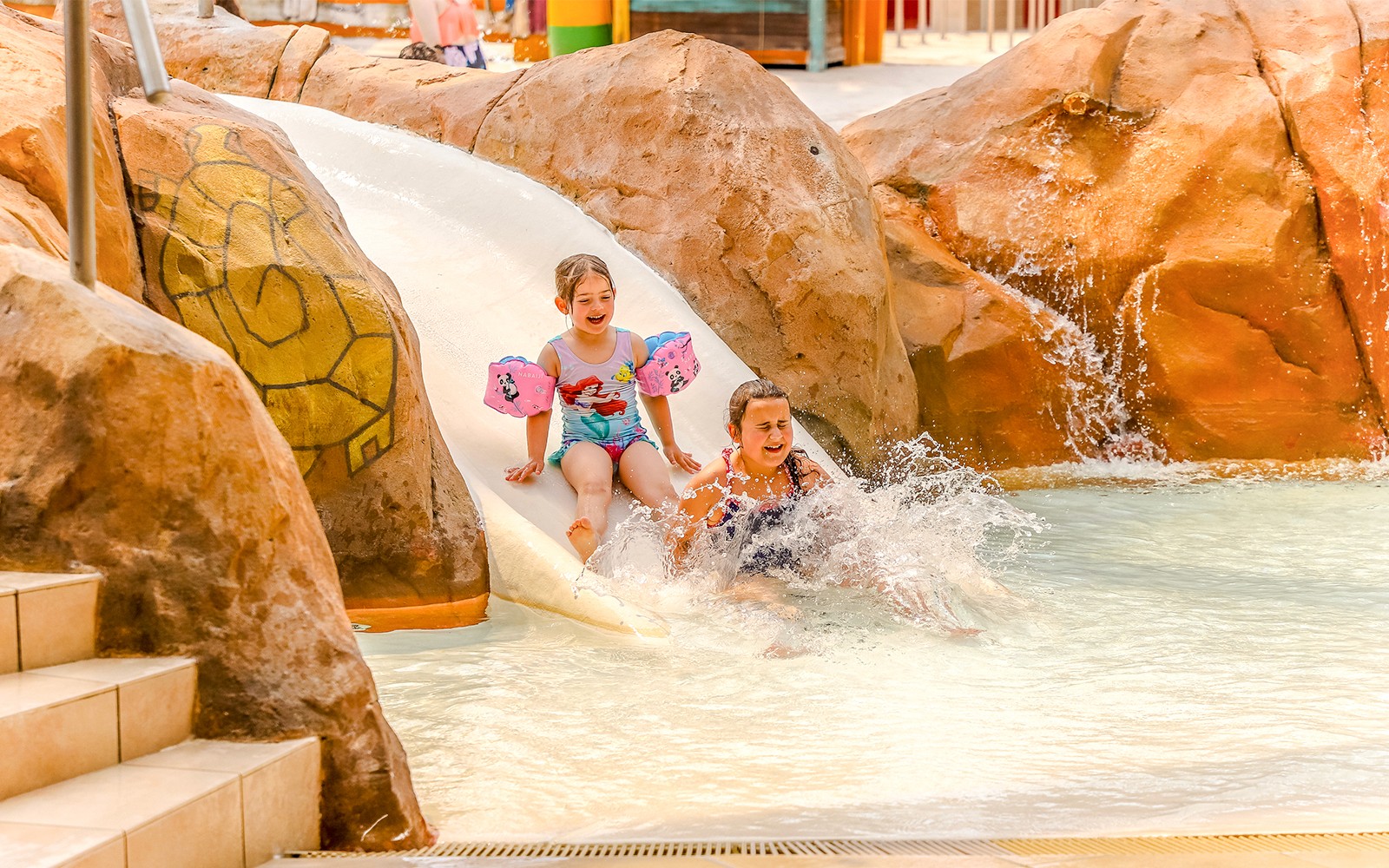 Children enjoying a water slide at Aqualibi Park, Belgium.