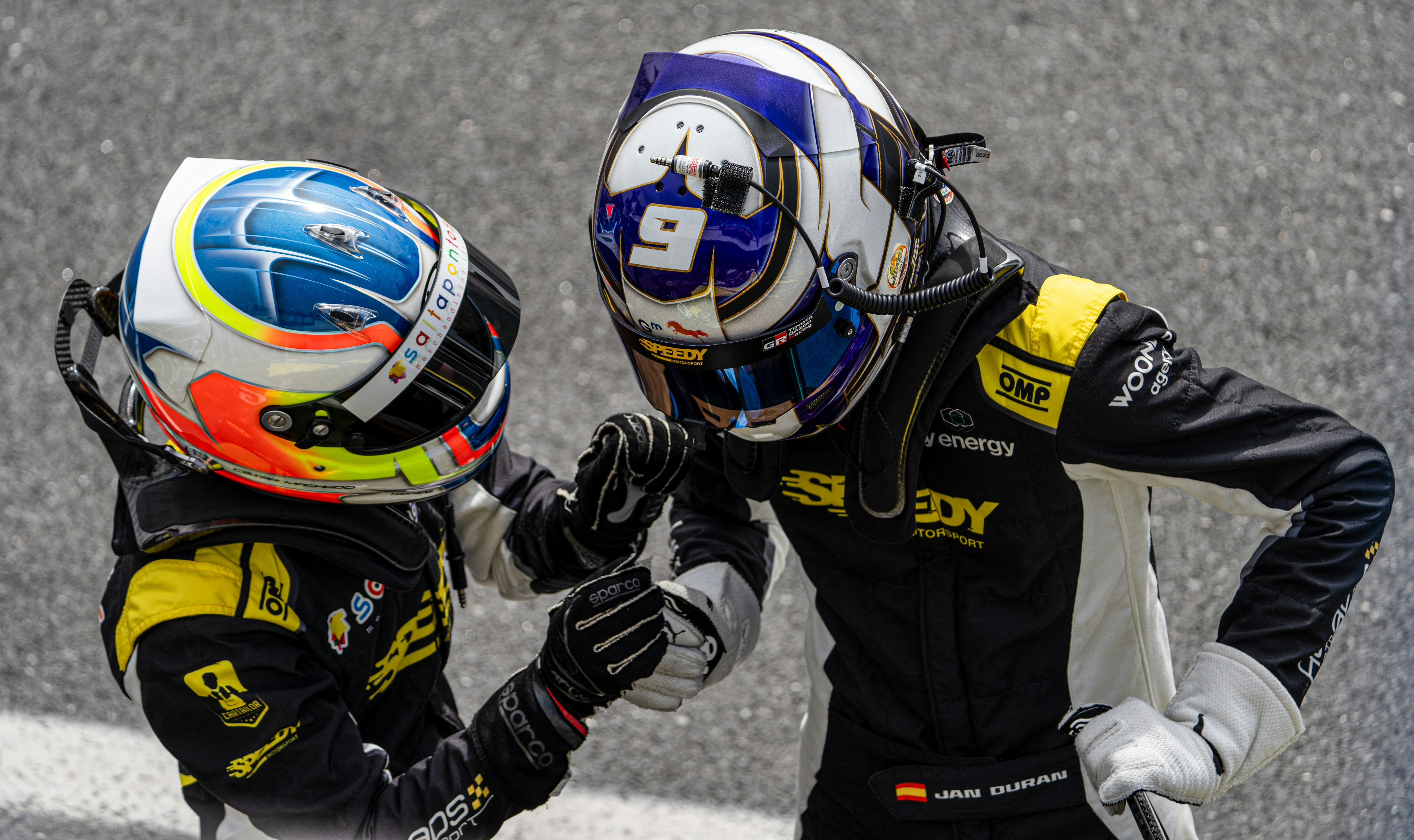 A couple of people standing next to each other on a race track