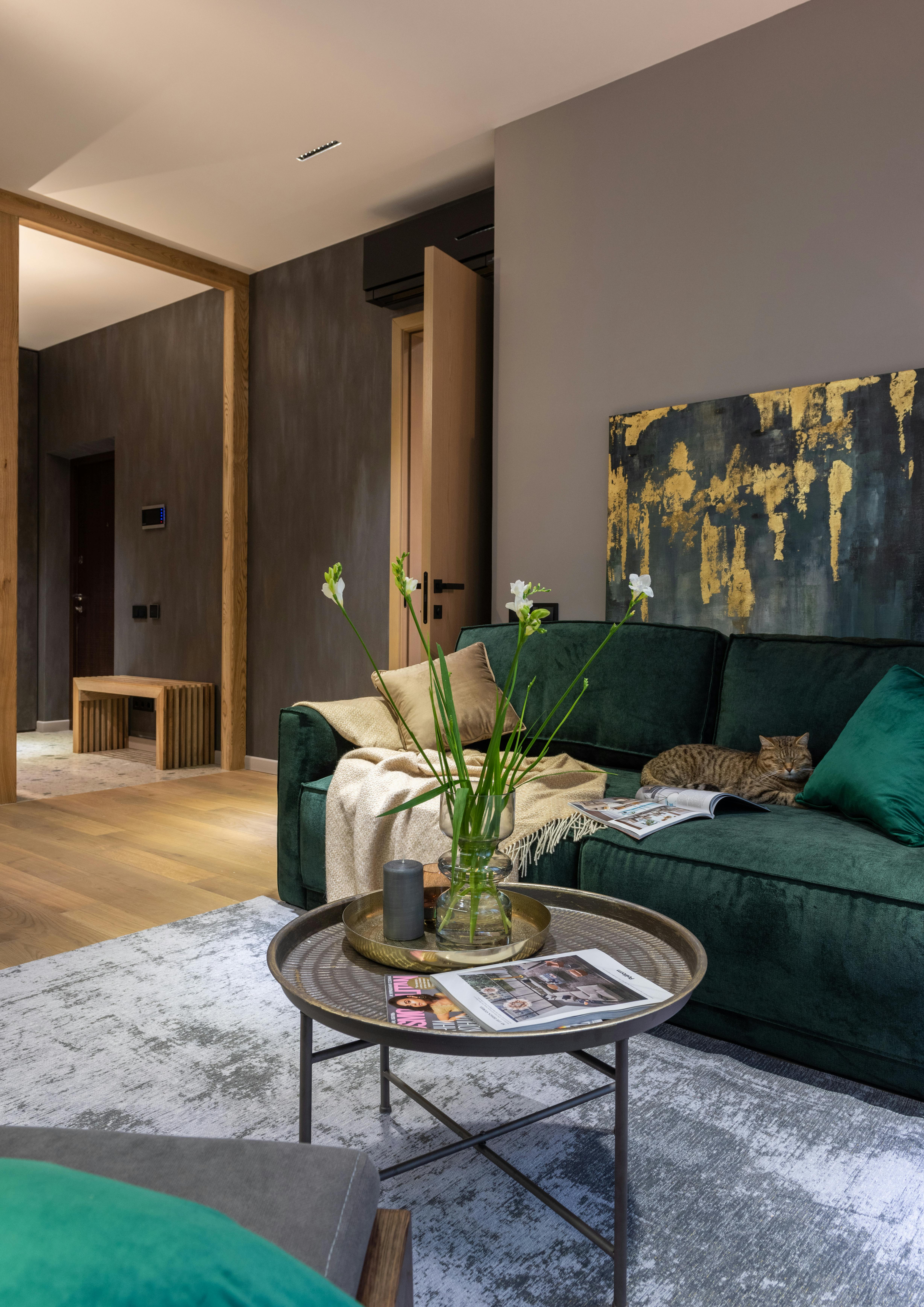 living room area with coffee table and green velvet sofa