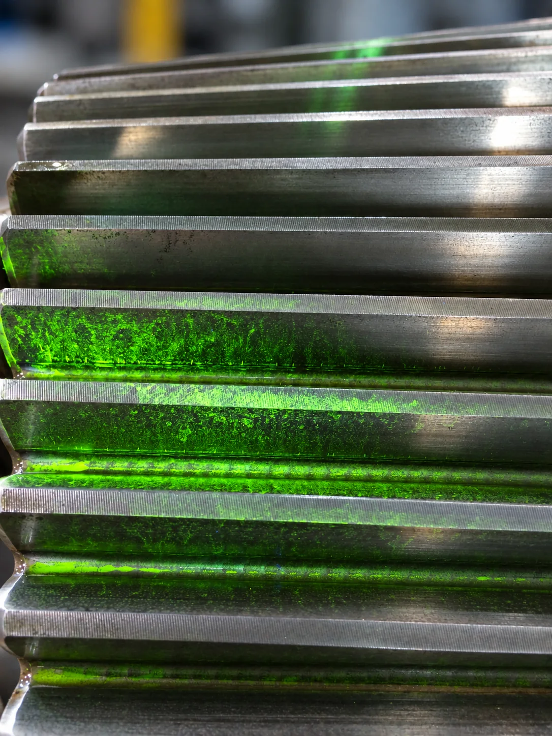 Magnetic NDT inspection showing fluorescent indications on gear teeth
