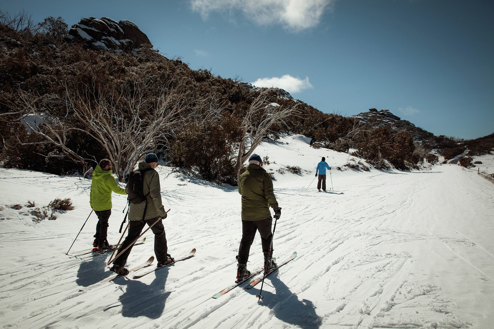 4 men cross country skiing on snow