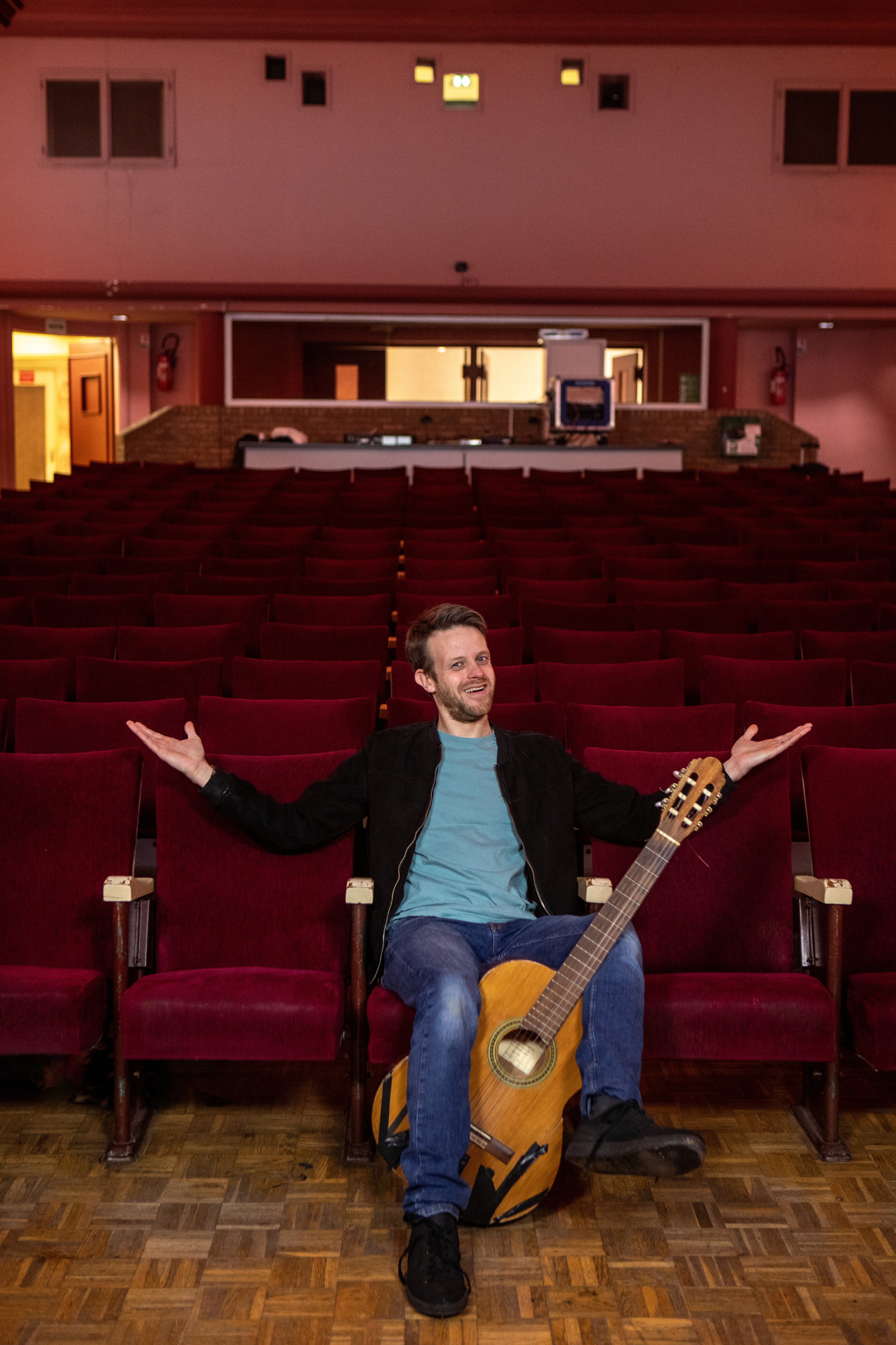 simon assis avec sa guitare