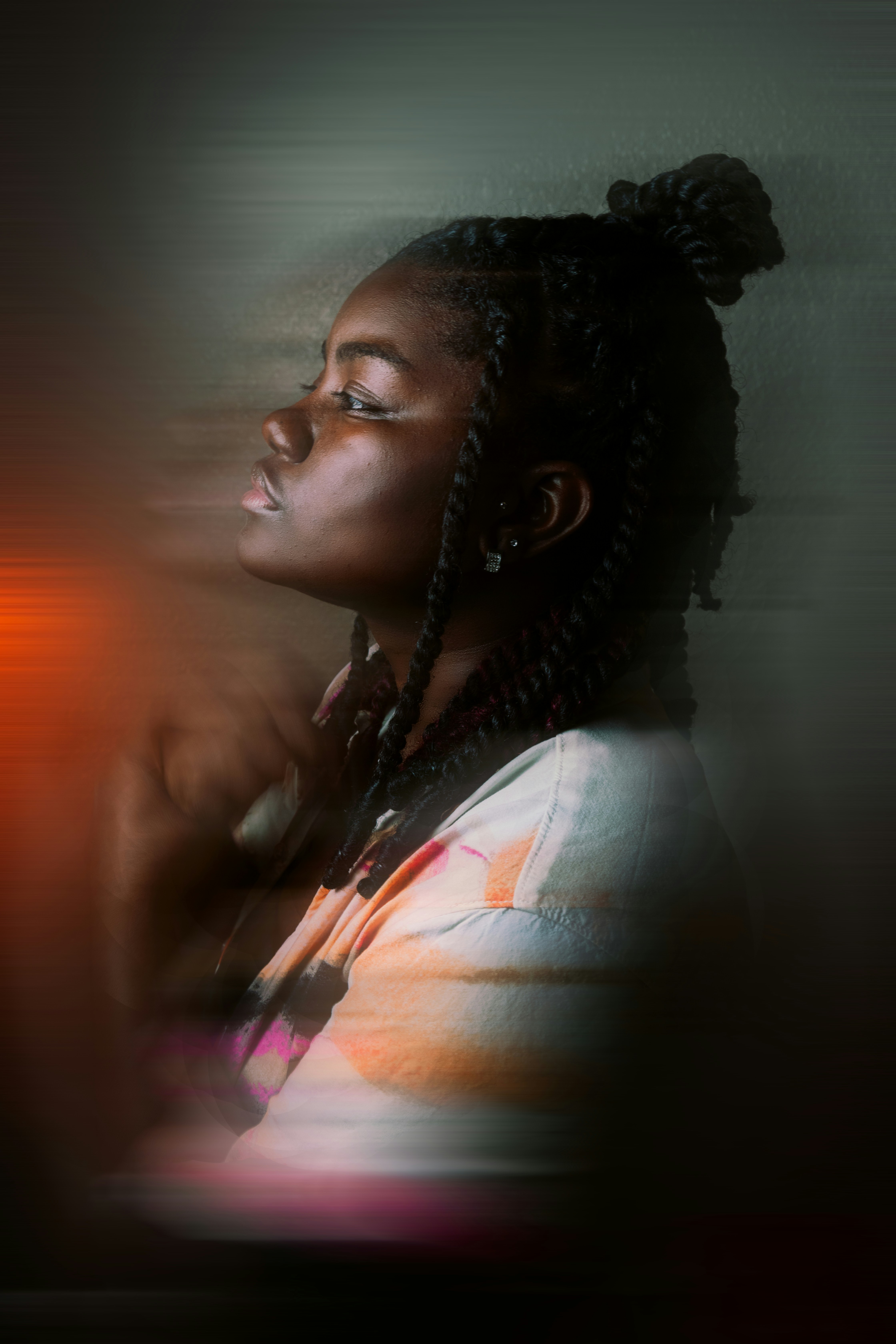 a woman with dreadlocks standing in front of a wall