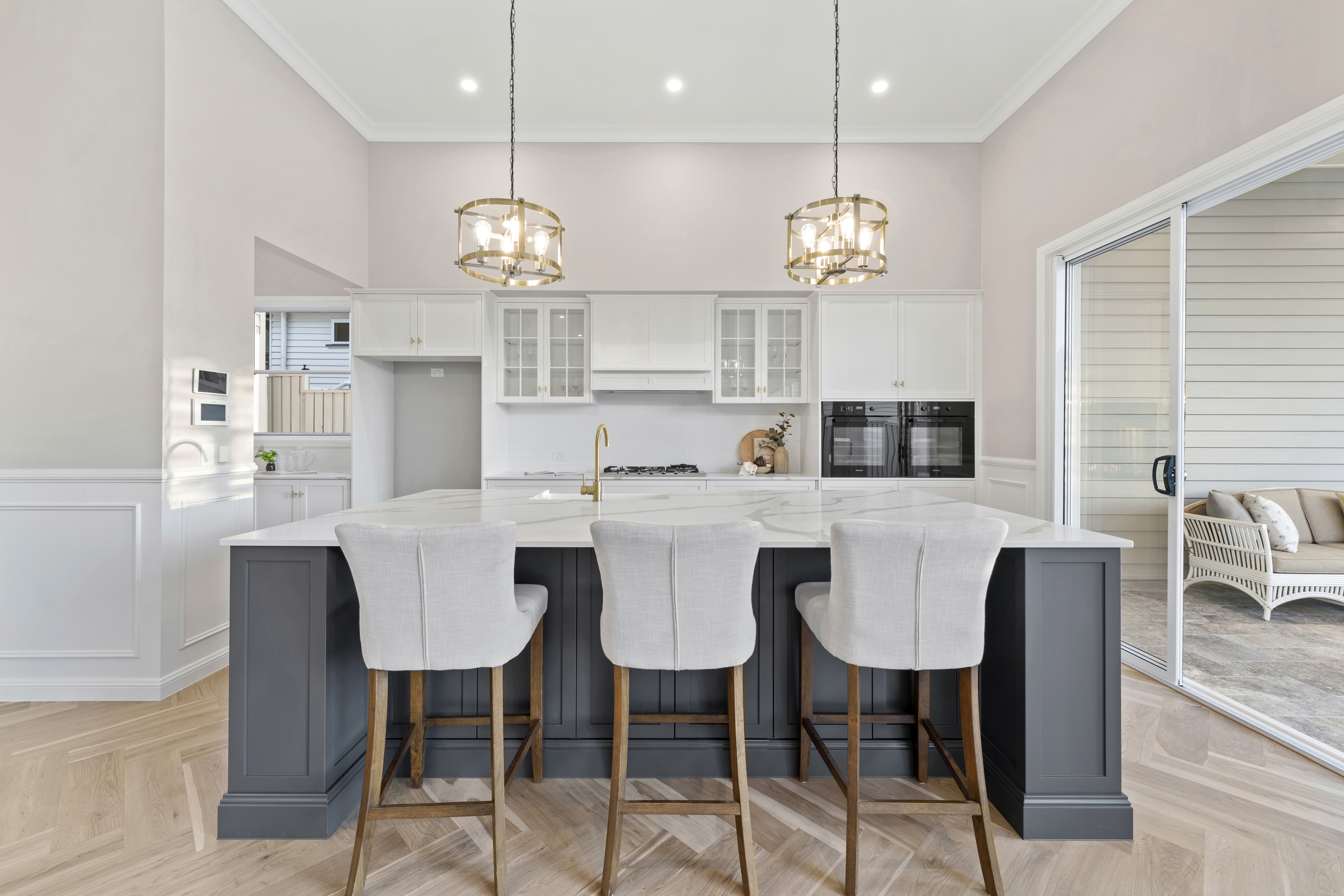 Custom luxury kitchen with a stone island and herringbone timber floors.