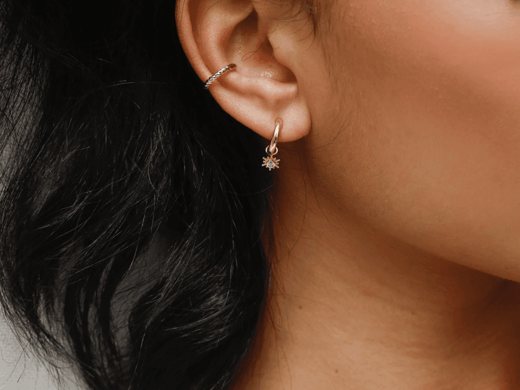 Silhouette féminine mise en lumière, ornée d’une boucle d’oreille Kube Store au design minimaliste.