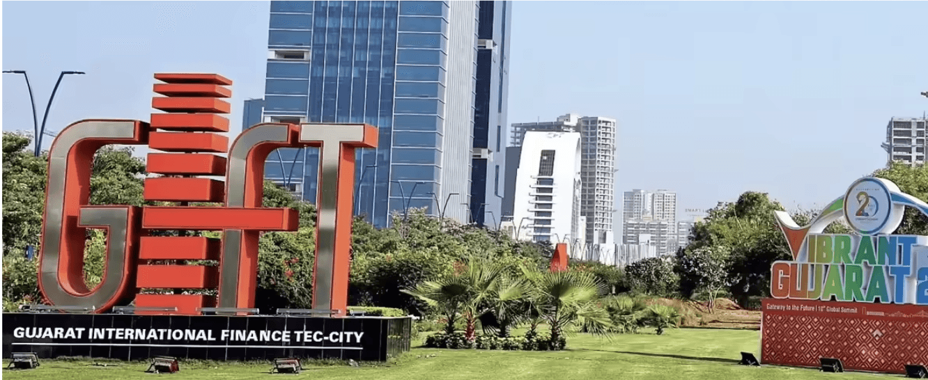 Close-up of a scientist holding a tray of petri dishes with purple cultures, wearing gloves and safety gear.