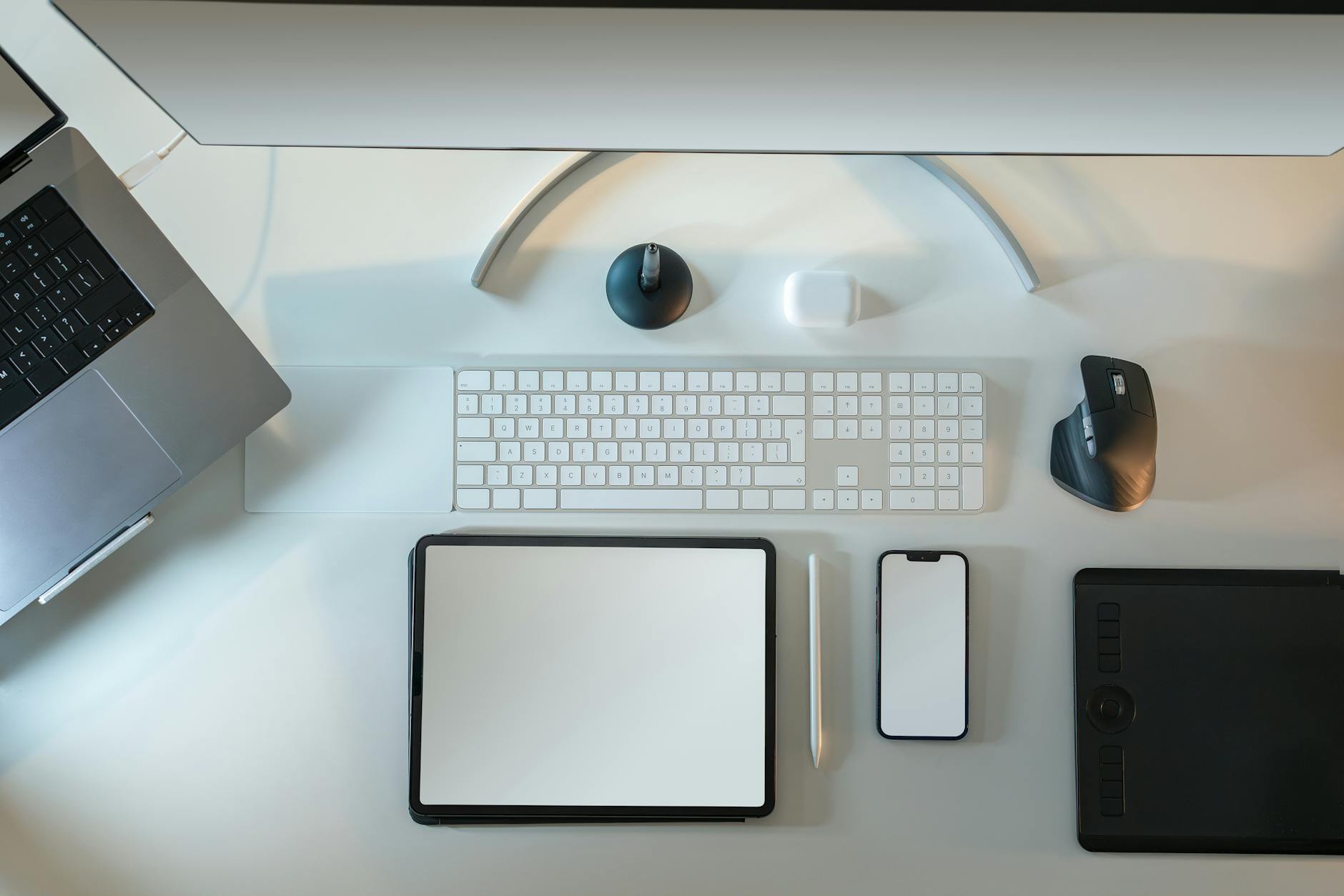 A top-down view of a desk with a smartphone, tablet, and notebook showing interconnected app icons and plugins.