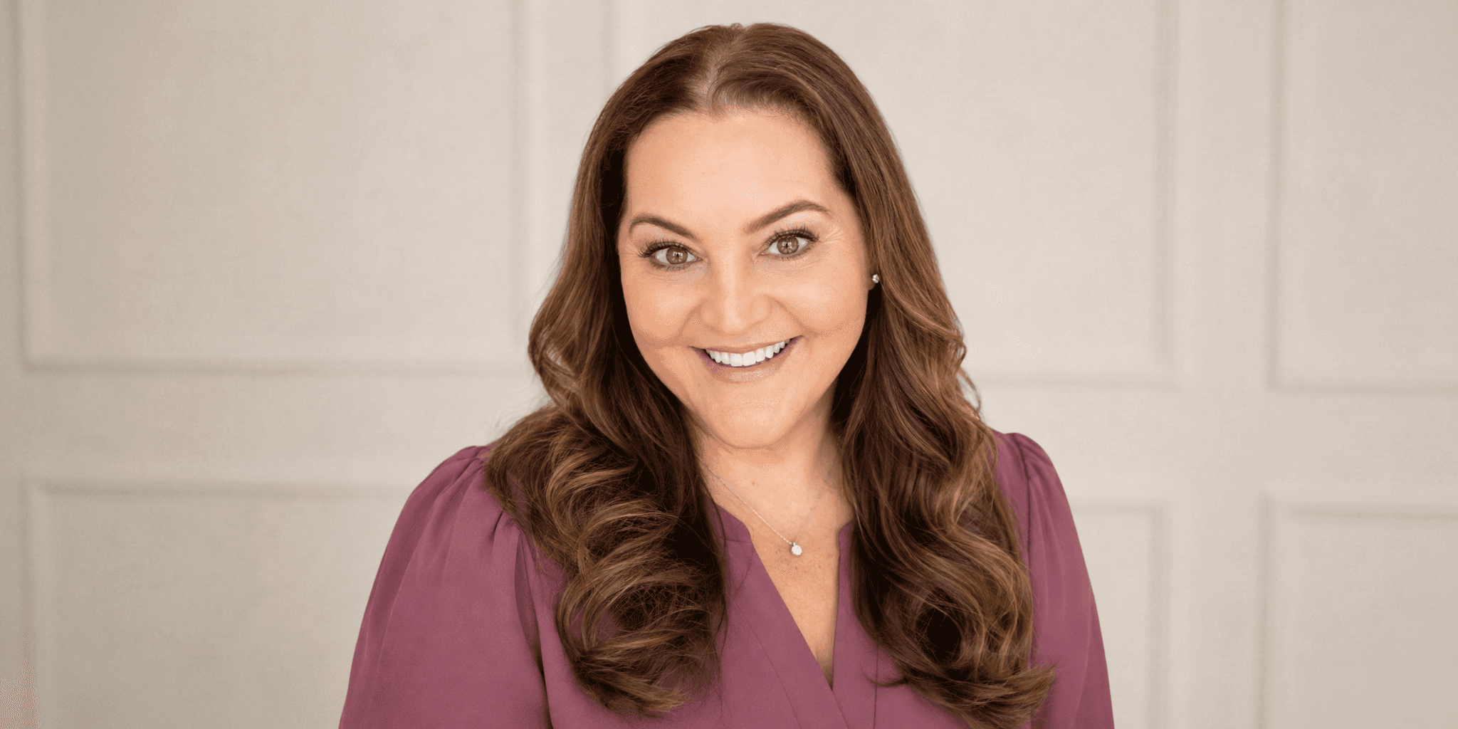 Professional portrait of Jackie Cook wearing a mauve blouse against a light neutral background.