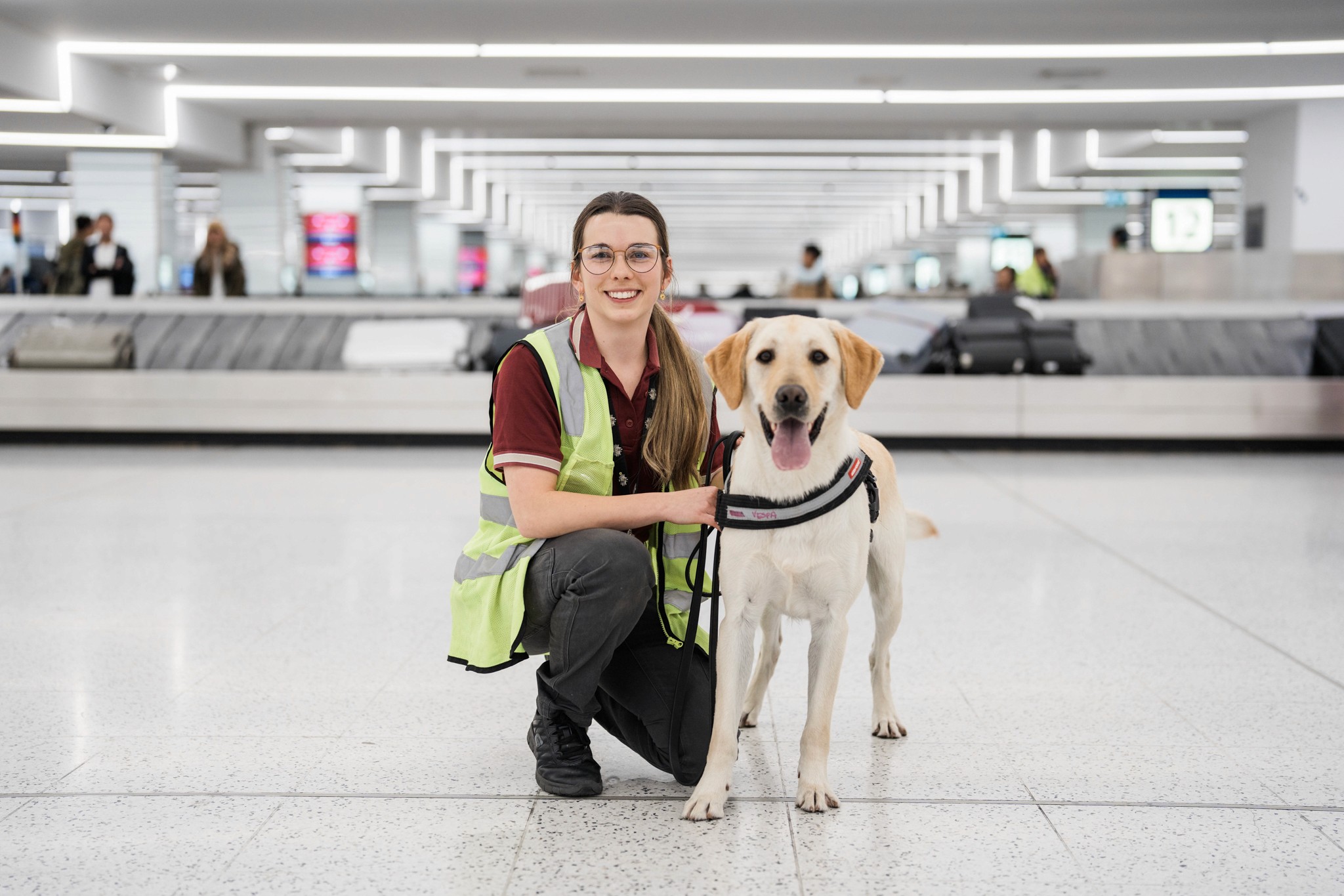 A woman and a dog in front of an airport