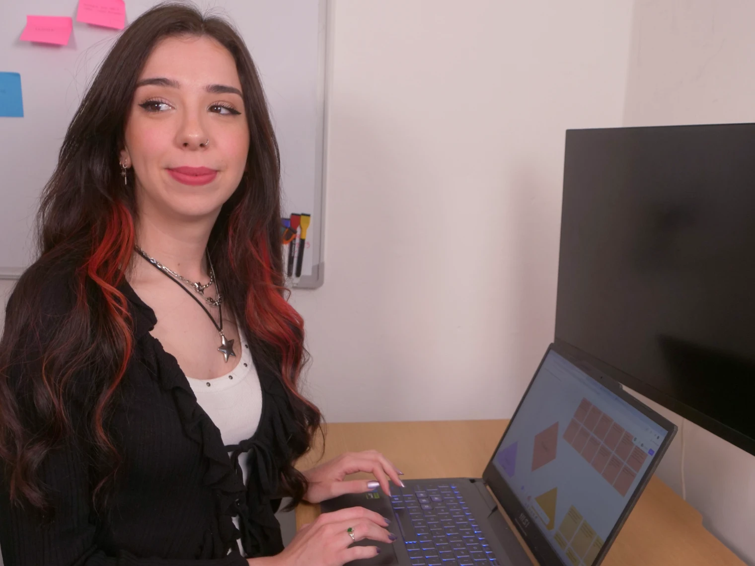 Lorena working as a freelance UX web designer on her desk