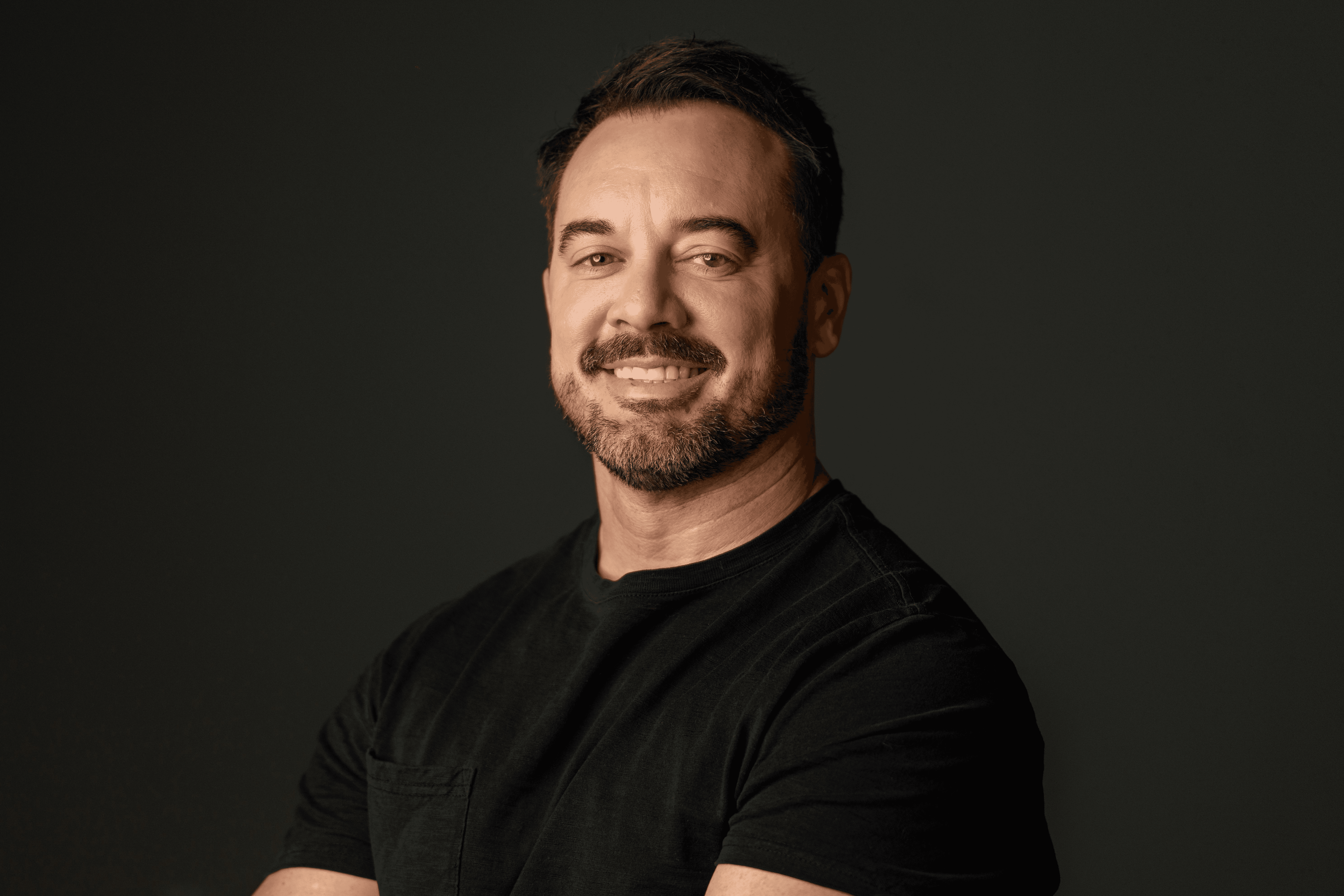 Chris Bruton sits in a yellow chair with a serious expression on his face.