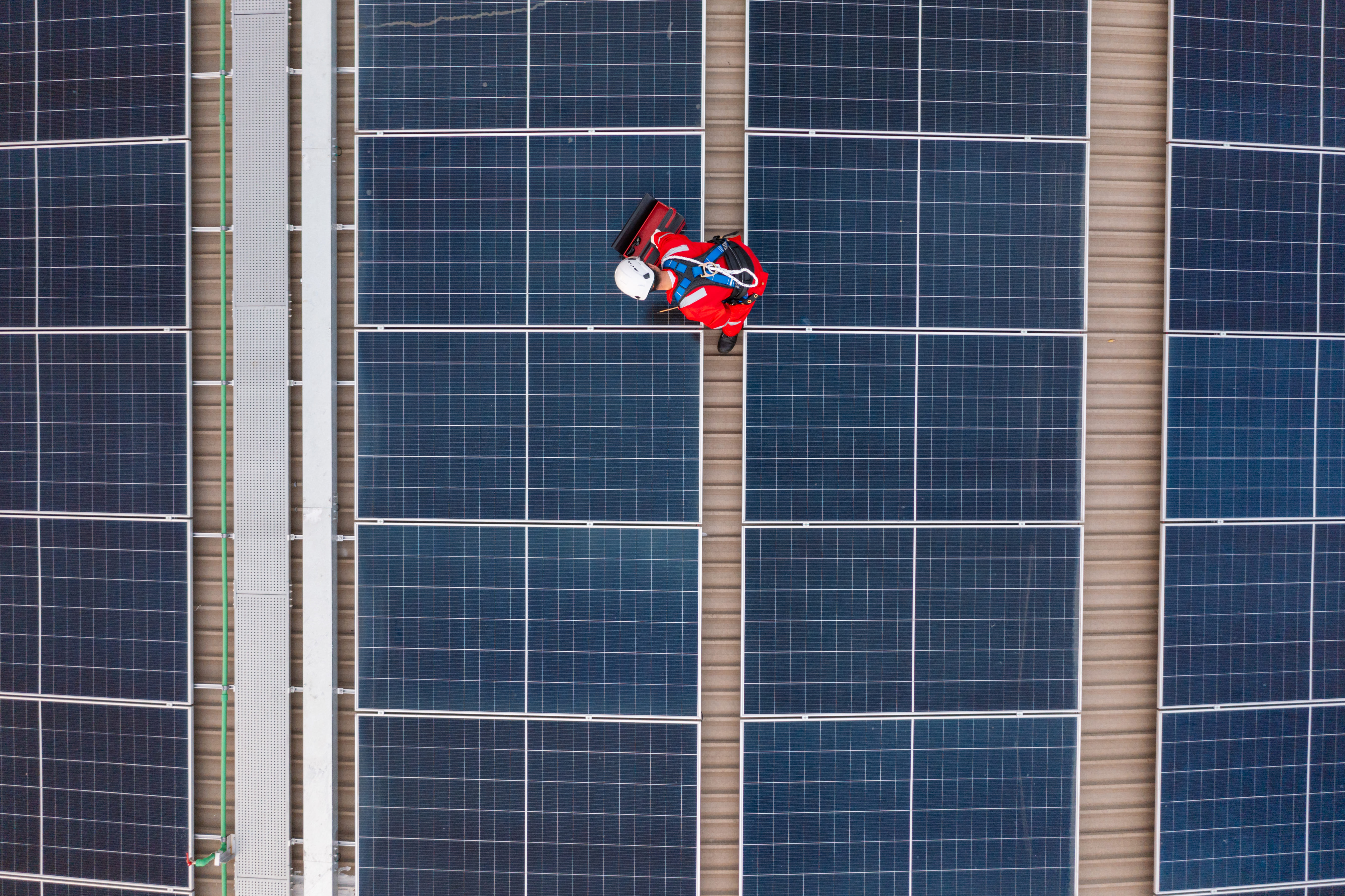 installatore-su-tetto-con-pannelli-fotovoltaici