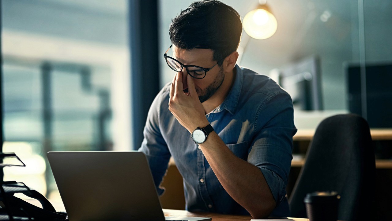 Man sitting at desk looking stressed