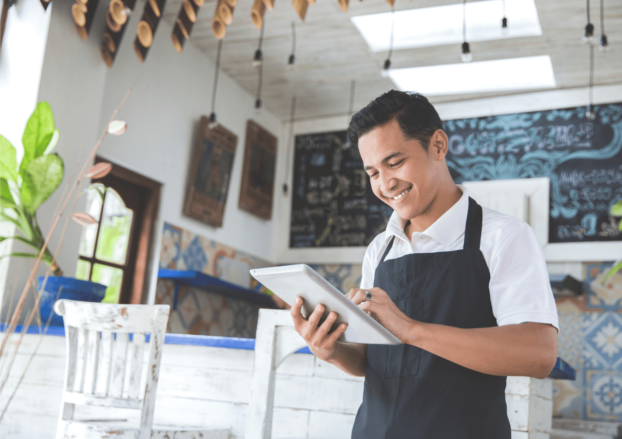 A manager holding a tablit and smiling as they work