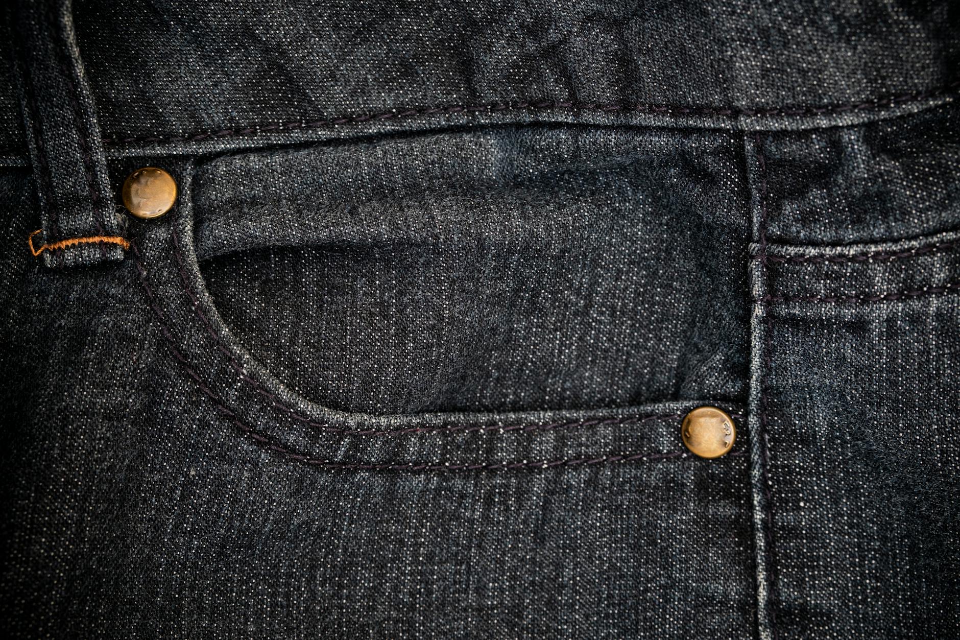 Detailed close-up of a denim jeans pocket showing stitching and texture.