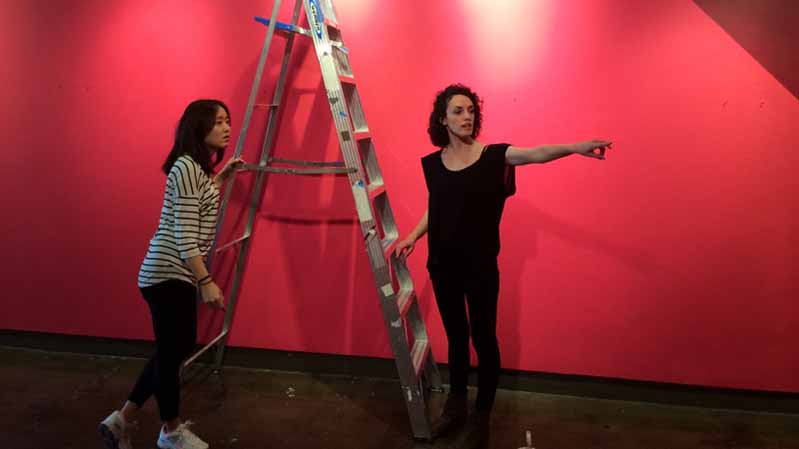 two women pointing to the right