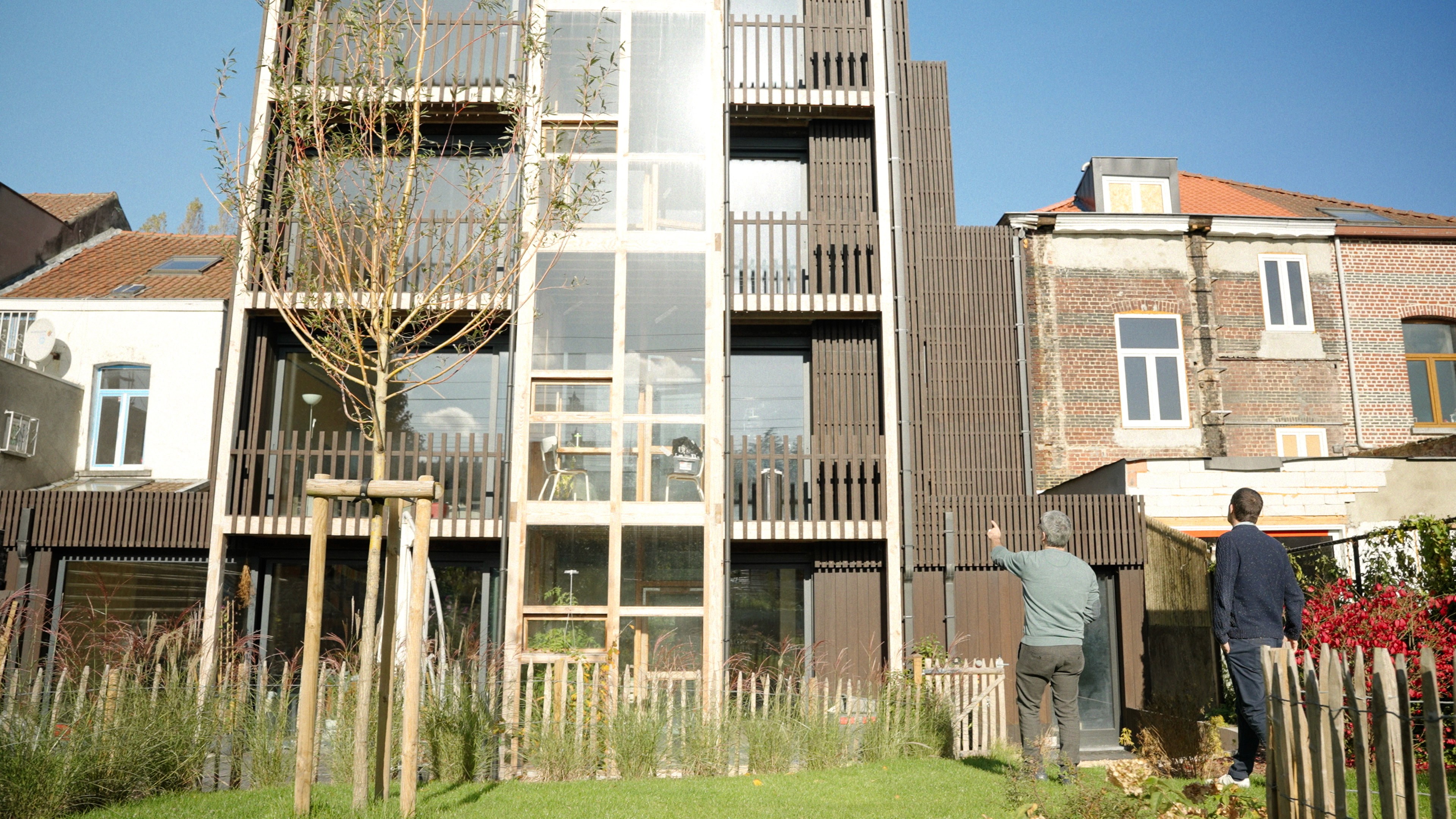 Two men talking in front of a modern designer house