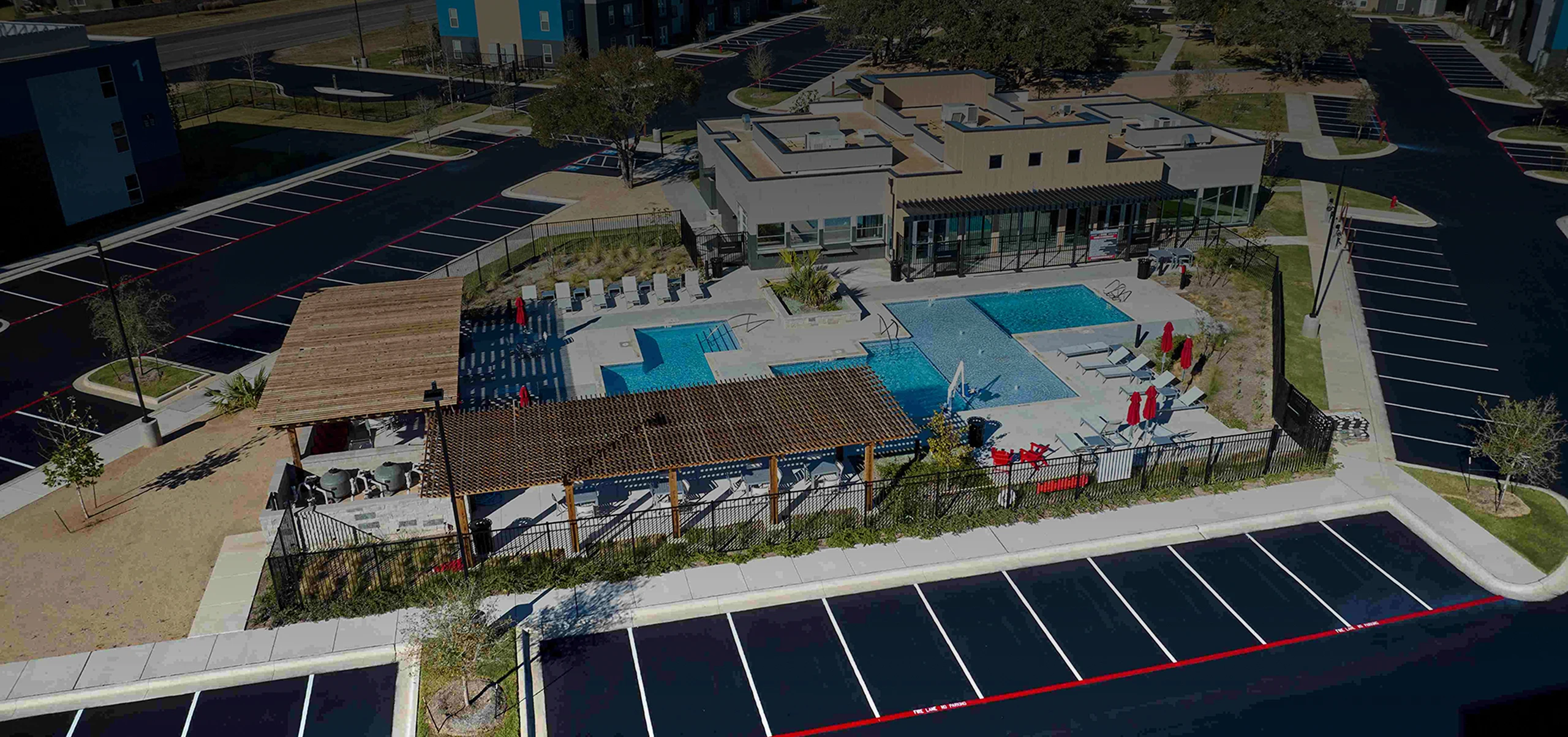 Overhead perspective of a pool adjacent to a parking lot, illustrating the spatial arrangement of both features.