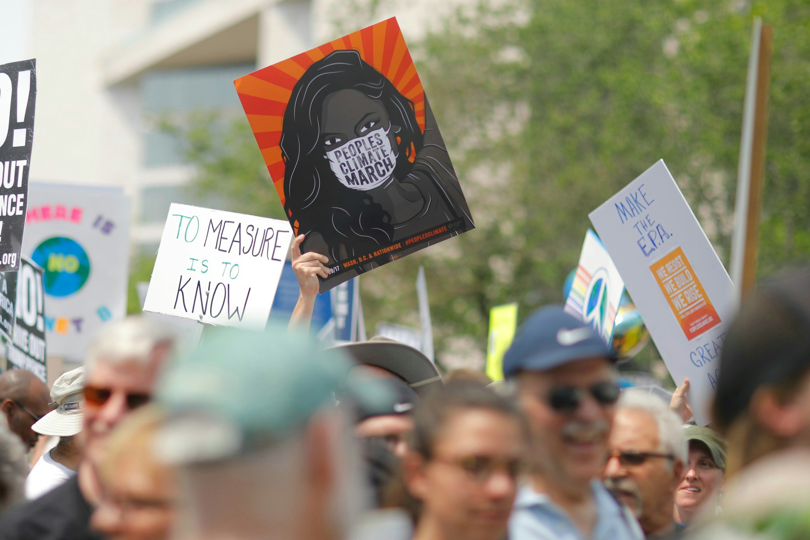 Crowd holding climate change protest signs at People's Climate March.
