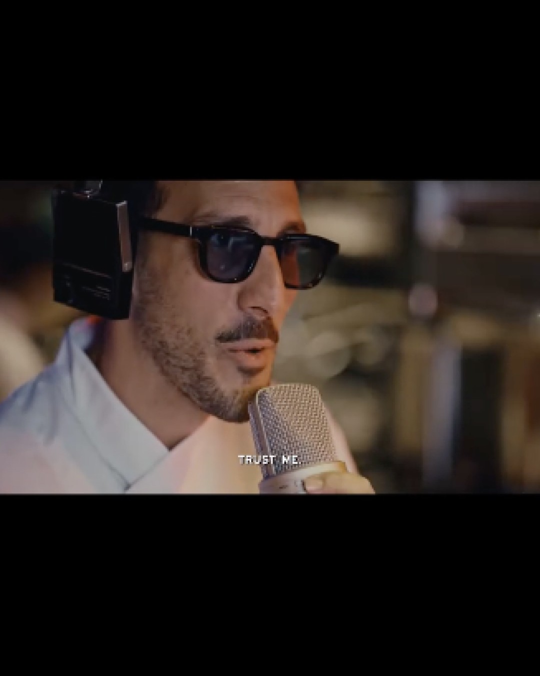 personne avec des lunettes de soleil et un micro
