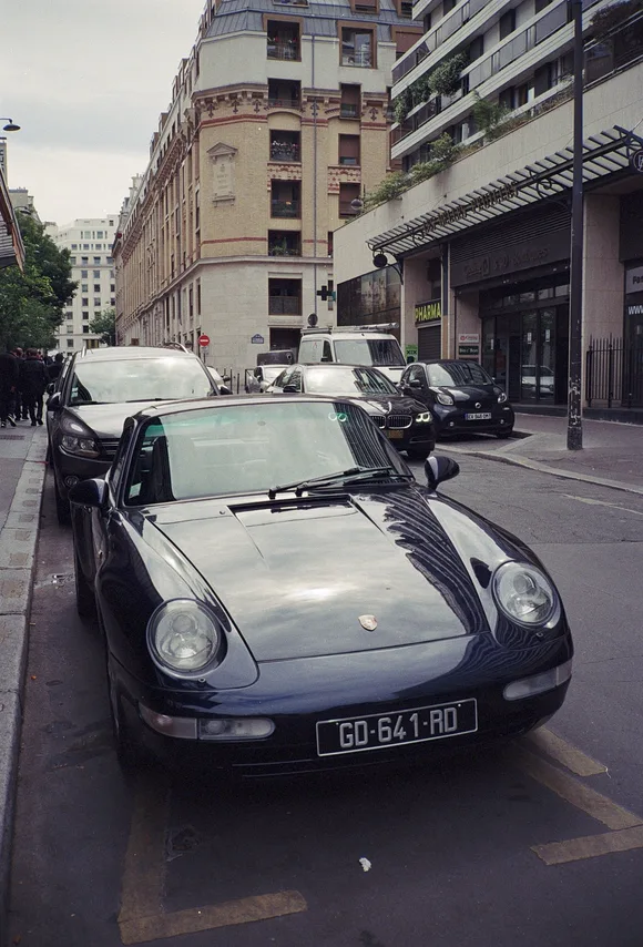 A vintage Porsche 911 parked on a street in Paris.