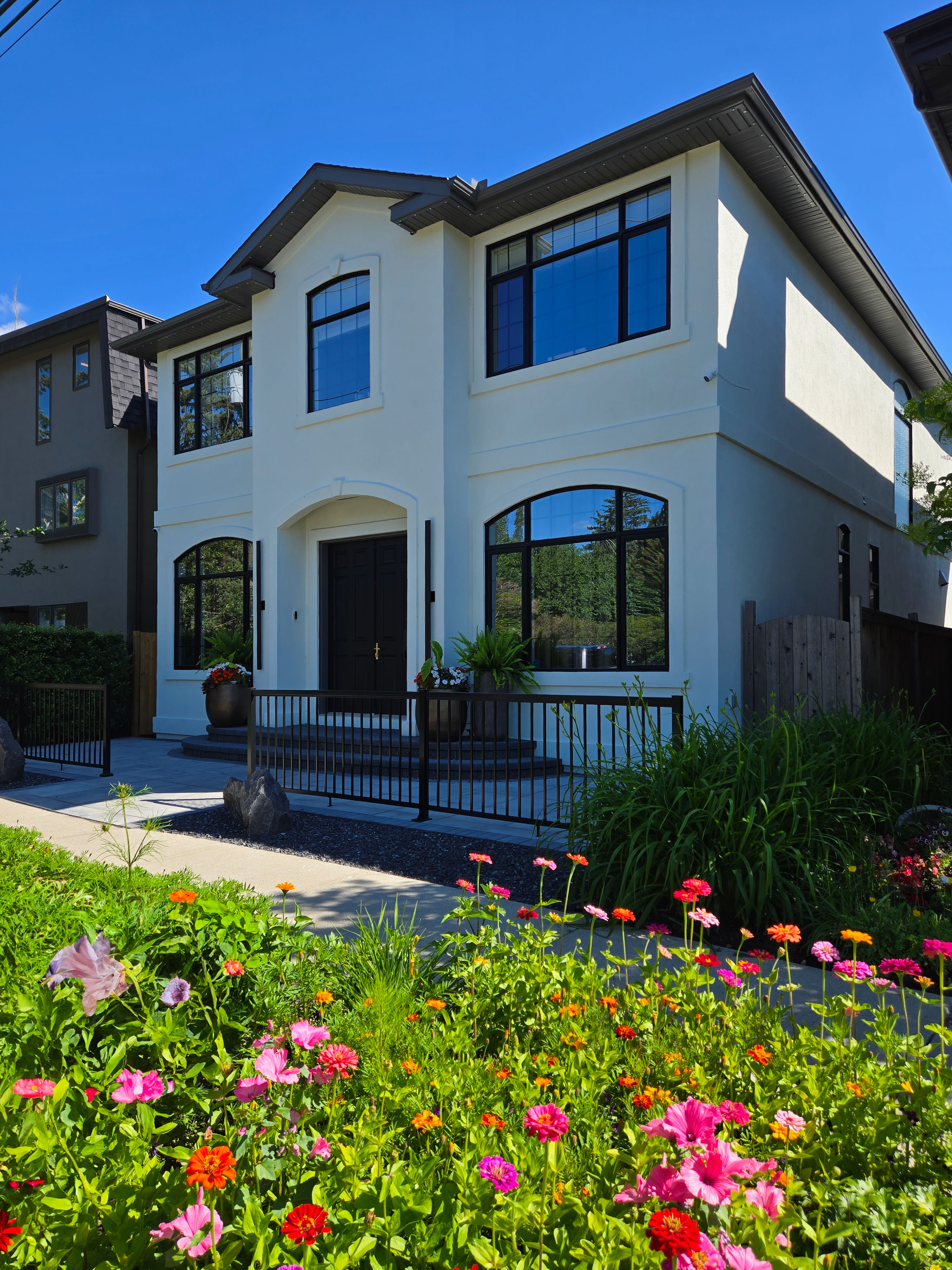 Image of KHD Homes exterior design with luxurious front entrance, large windows, and decorative planters.