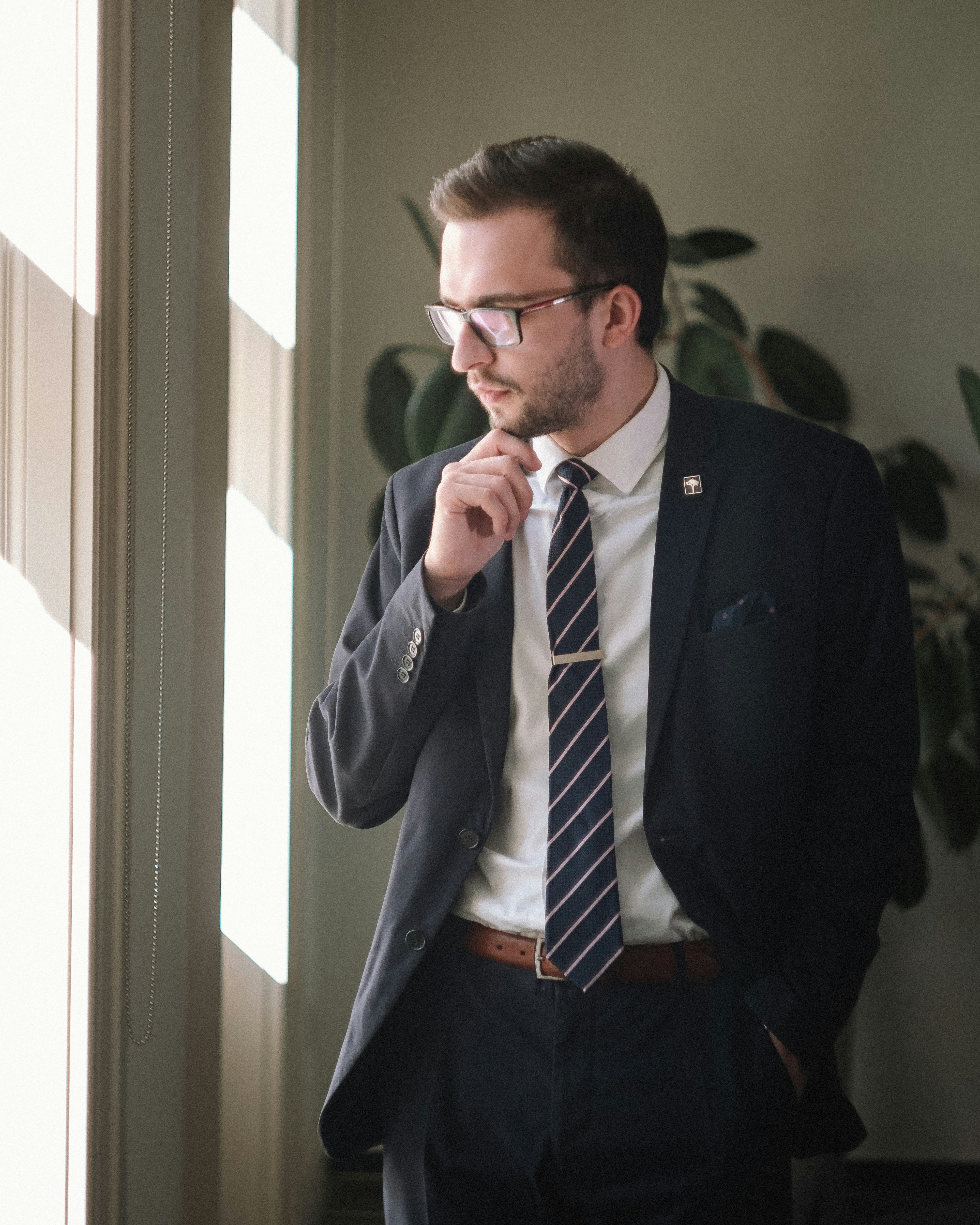 Image of person weaing black suit, glasses, and tie