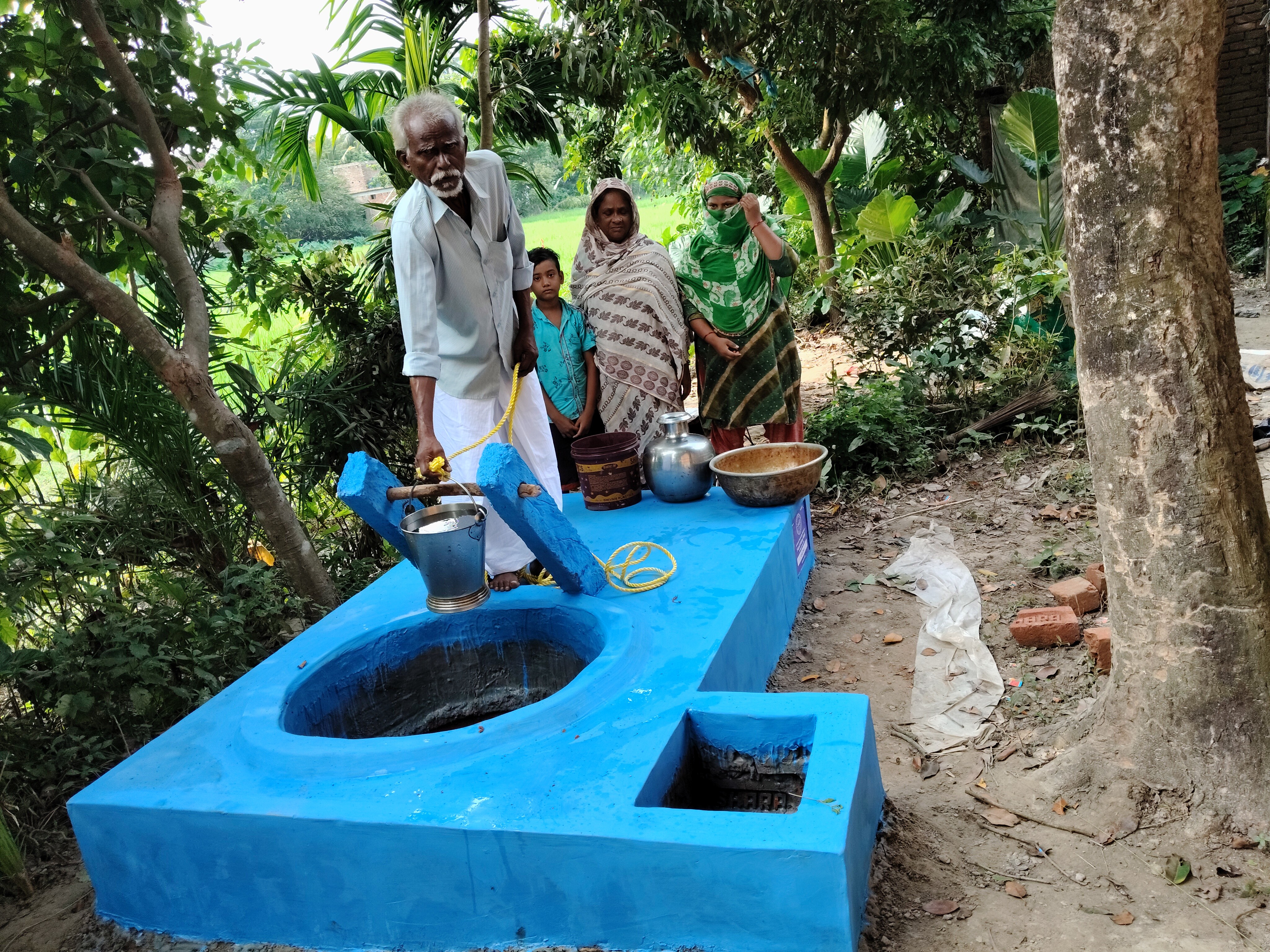 a family gathering to collect fresh water from a well
