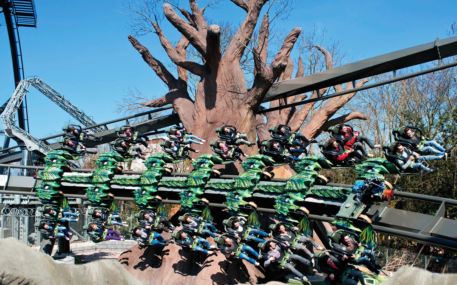 Rússíbanaferð með farþegum í Gardaland Park, Ítalíu, þar sem er stór trjástrúktúr.